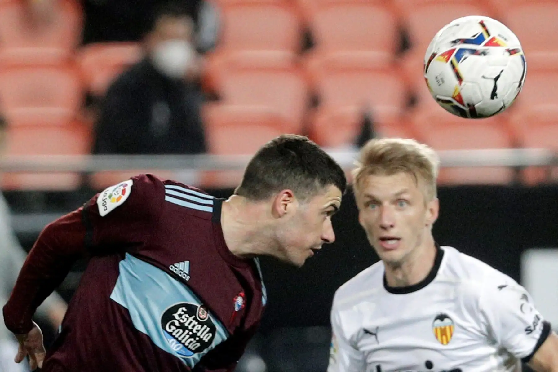El jugador del Celta, Aaron Martín, remata de cabeza ante el jugador del Valencia, Daniel Wass, durante el partido de La Liga Santander de la jornada 24 que disputan en el estadio de Mestalla. 
Foto: EFE