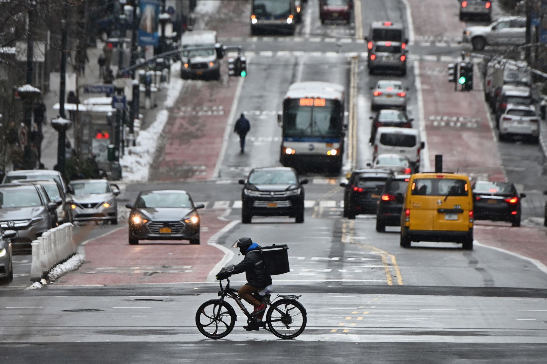 Un hombre en una bicicleta de reparto viaja en la calle después de que una tormenta invernal azotara la ciudad de Nueva York, en medio de la pandemia. Foto: AFP