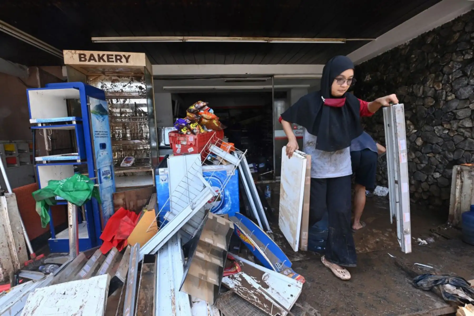 Las personas sacan artículos dañados por las inundaciones de una tienda en Kemang en Yakarta después que varias zonas de la capital de Indonesia se inundaron por las fuertes lluvias estacionales.

Foto: AFP