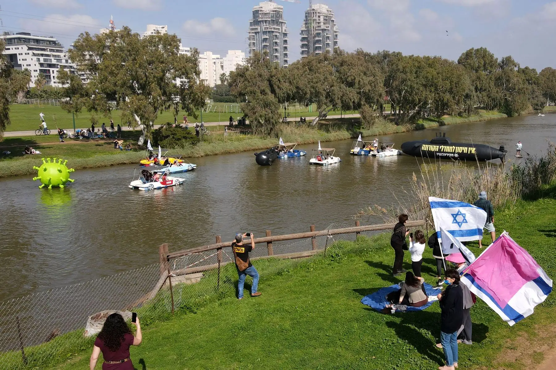 Objetos inflables una representación del coronavirus por el río Yarkon, mientras los israelíes protestan en medio de la crisis por la pandemia. Foto: AFP