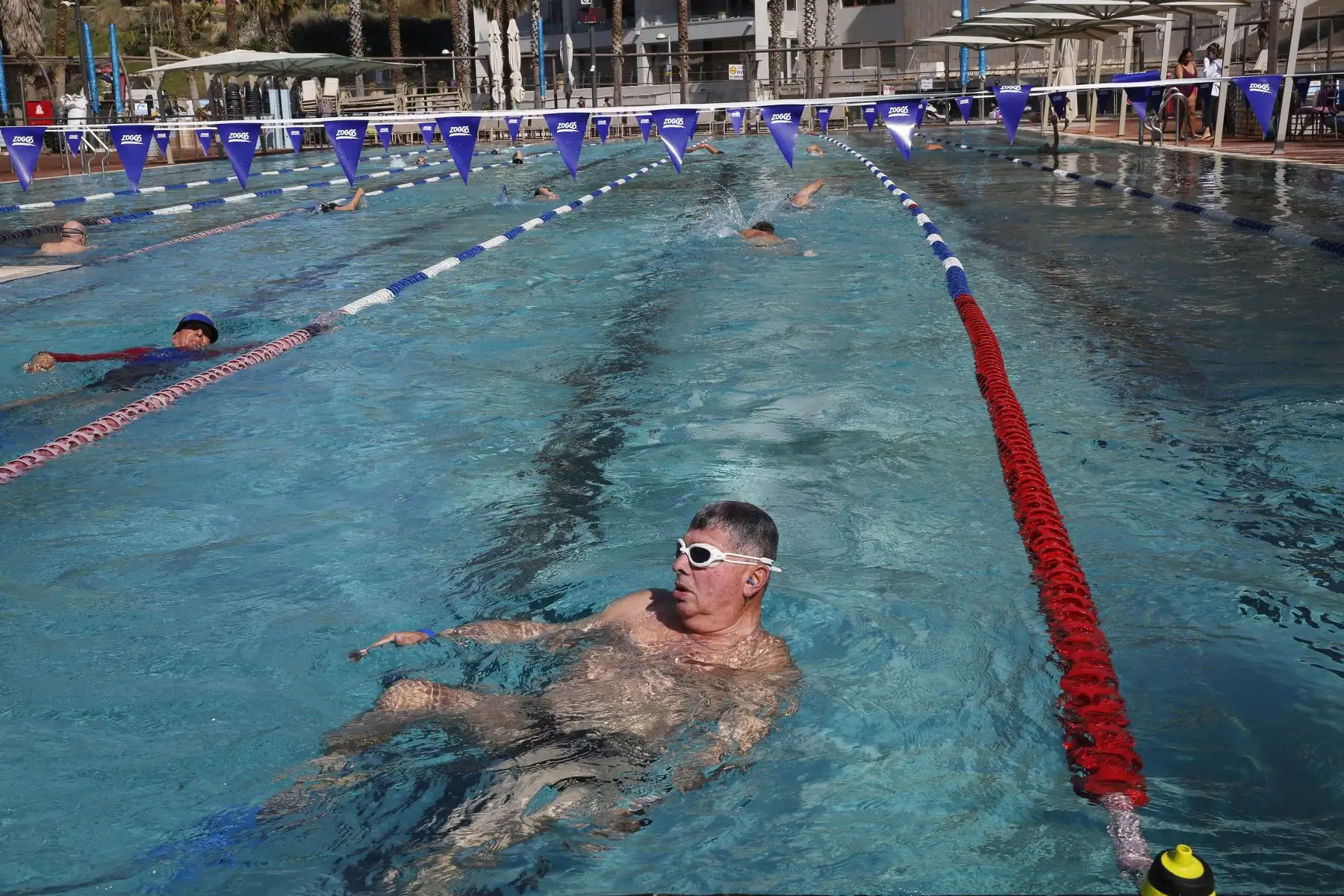Las personas disfrutan de la piscina después de ingresar a las instalaciones con su "pase verde", requerido como prueba de estar vacunados contra el coronavirus, en la ciudad costera israelí de Tel Aviv, Foto: AFP