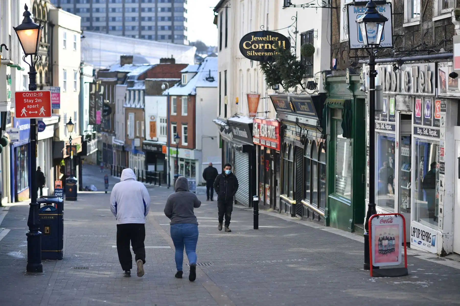 Los peatones caminan por una calle principal con las tiendas cerradas en Maidstone, sureste de Inglaterra, el 12 de febrero de 2021 mientras la vida continúa en el tercer cierre de coronavirus. Foto: AFP