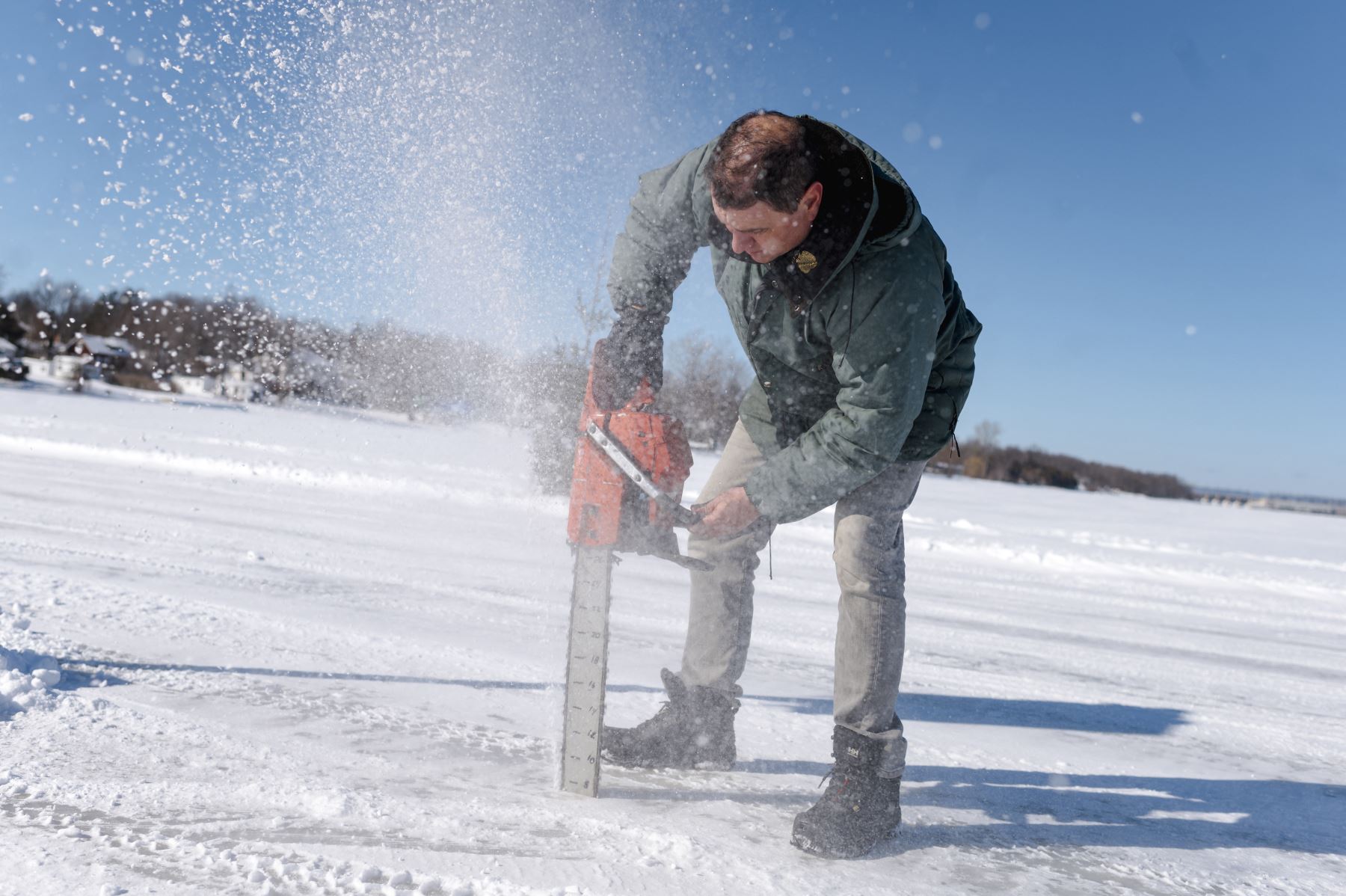Gilbert Cardin, usa su motosierra para verificar la profundidad del hielo en Pointe-Fortune, Quebec, Canadá. Foto: AFP