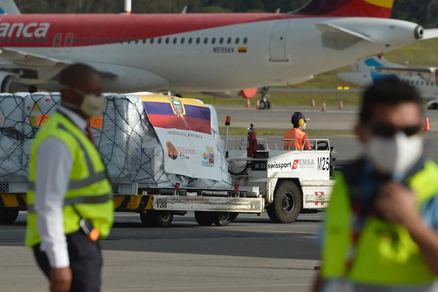 Trabajadores descargan un contenedor con las primeras 8000 dosis de la vacuna Pfizer BioNTech COVID-19 en el Aeropuerto Internacional Mariscal Sucre de Quito, el 21 de enero de 2021. Foto: AFP