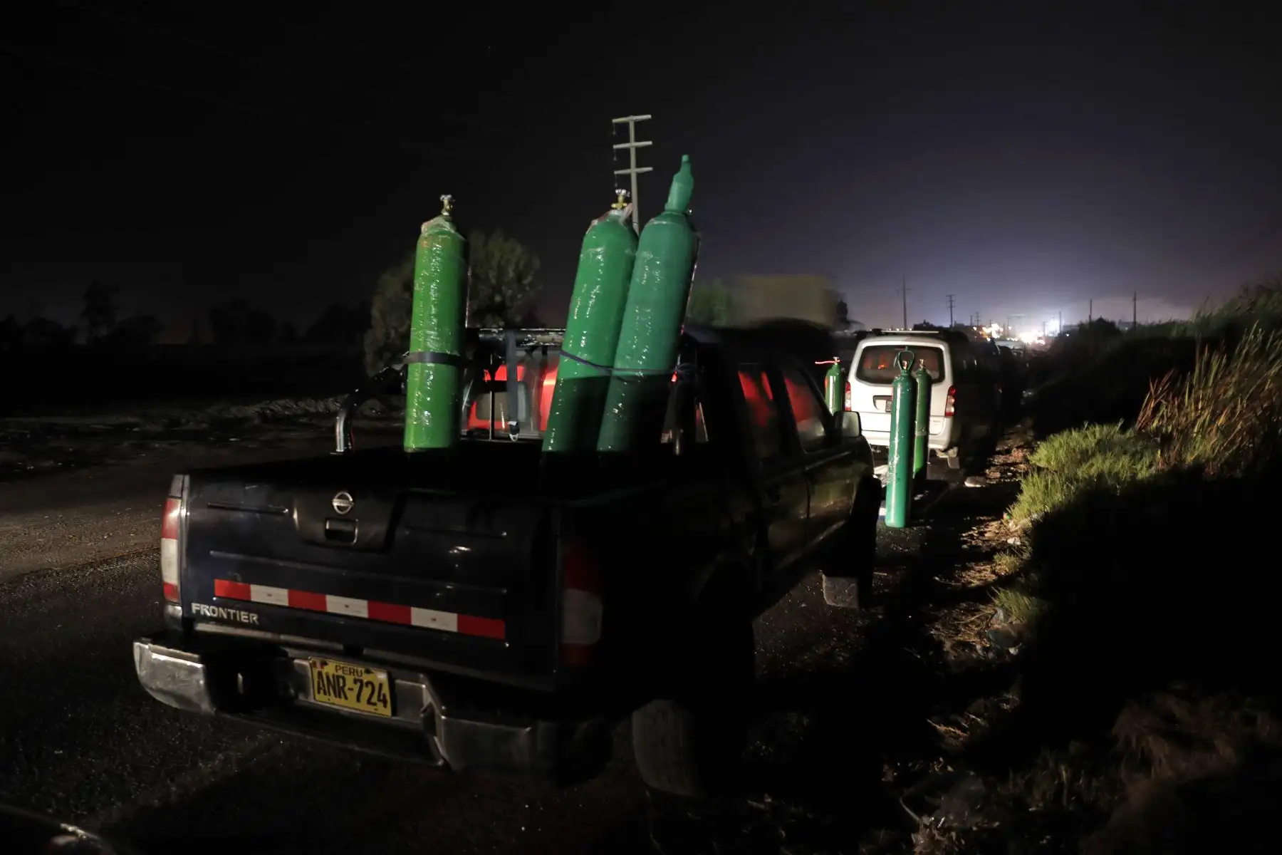Decenas de personas esperan en sus coches para obtener oxígeno medicinal en la ciudad de Pisco. Ellos viajan alrededor de 230 kilómetros, desde Lima hasta la ciudad sureña de Pisco, para llevar a casa el oxigeno medicinal que sus familiares necesitan de urgencia para combatir la covid-19, el 20 de febrero 2021. Foto: EFE