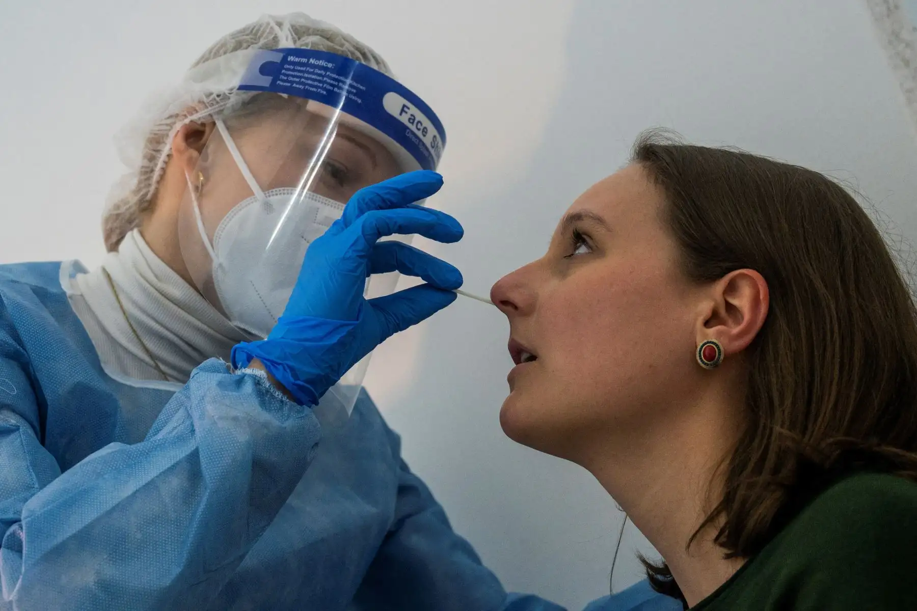 Un profesional de la salud toma una muestra de un paciente con un hisopo para una prueba rápida de antígeno Covid-19 en un centro especializado de Berlín el 17 de febrero de 2021. Foto: AFP