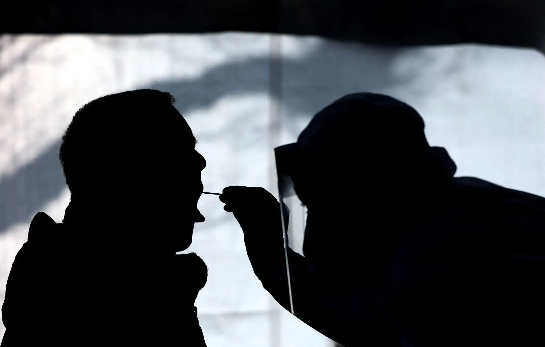 Un trabajador de la salud examina a una persona en un centro gratuito de pruebas rápidas Covid-19 el 3 de febrero de 2021, en Naumburg, Alemania oriental. Foto: AFP