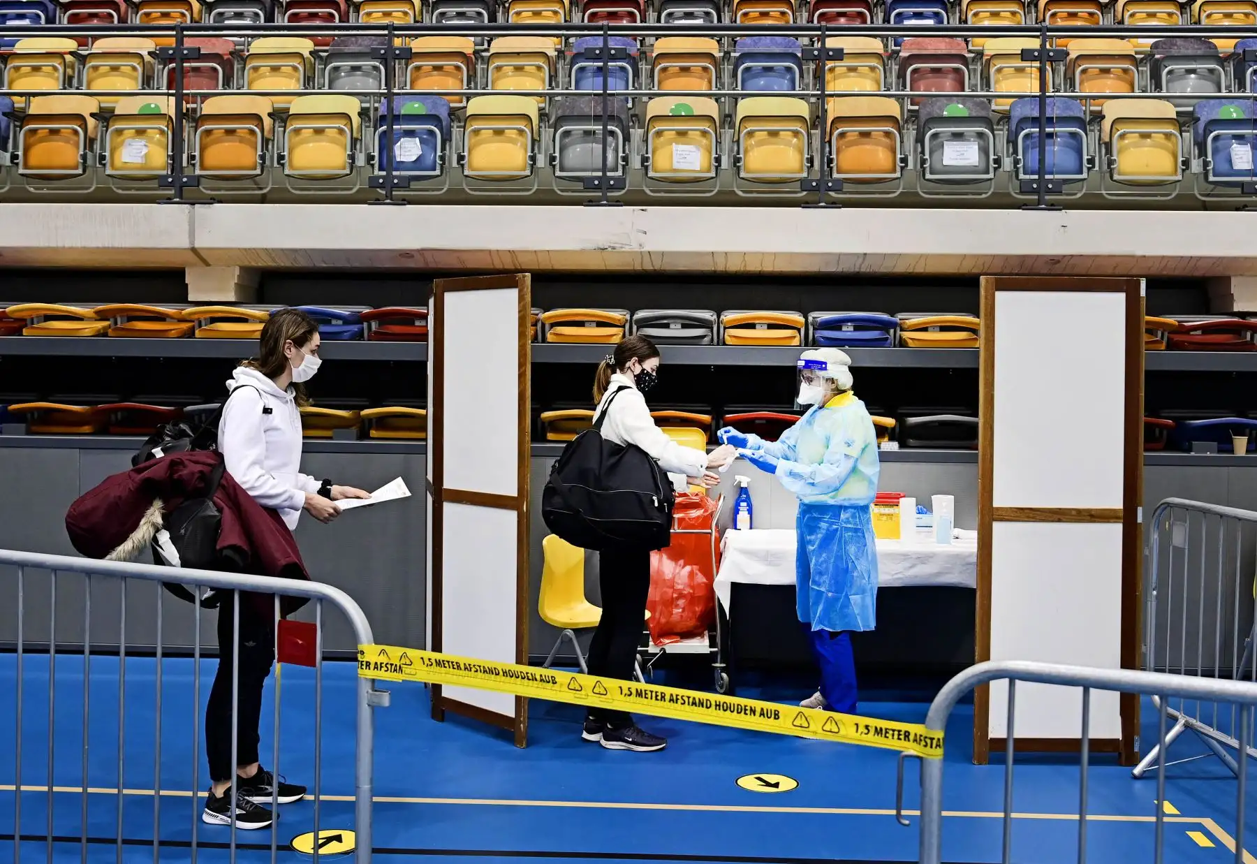 La gente espera para hacerse la prueba del Covid-19 durante el campeonato holandés de atletismo en Apeldoorn, Holanda, el 20 de febrero de 2021. Foto: AFP