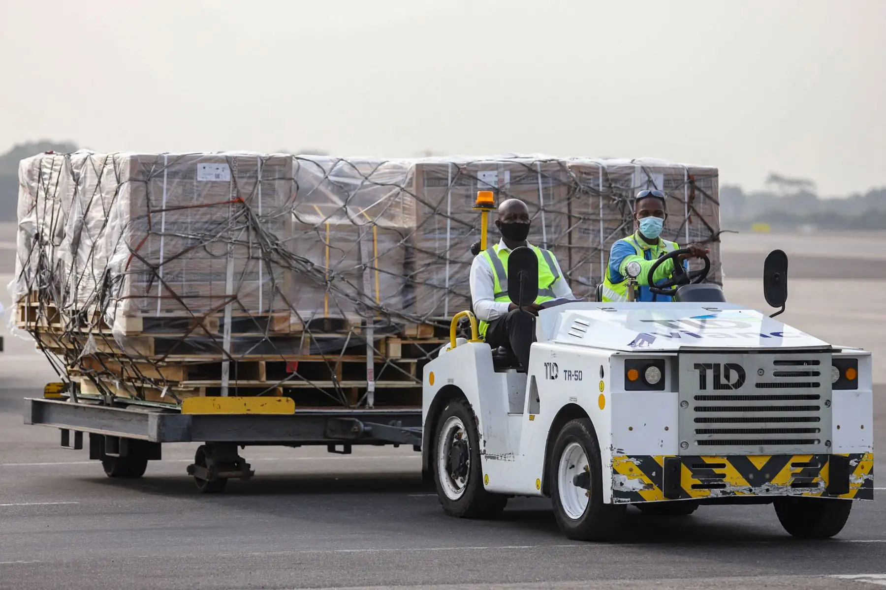 Los trabajadores transportan un lote de vacunas AstraZeneca/ Oxford contra la Covid-19 adquiridas por Ghana a través del mecanismo COVAX, en el Aeropuerto Internacional de Kotoka en Accra, el 24 de febrero de 2021. Foto: AFP