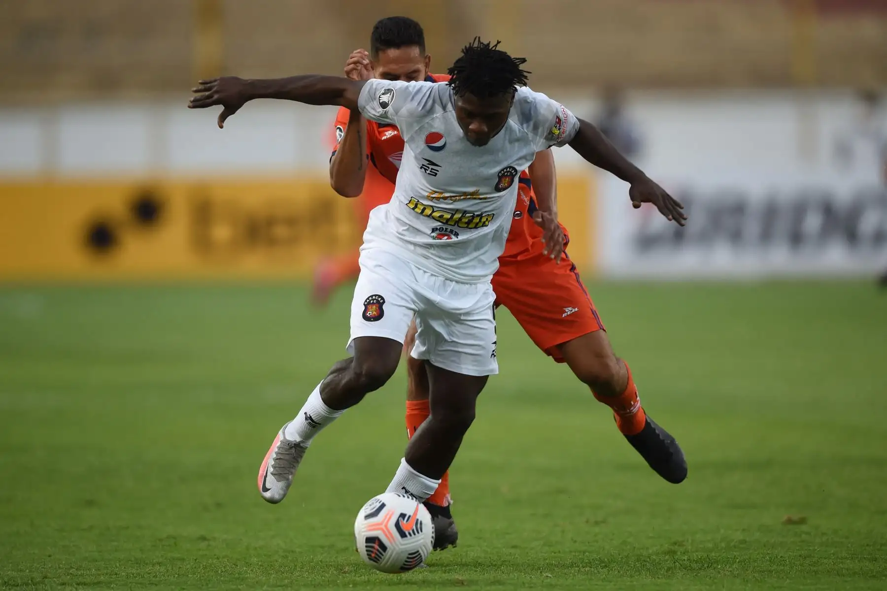 El nigeriano-beninés Samson Akinyoola, de Caracas y Renzo Garcés de César Vallejo disputan el balón durante el partido de fútbol de la Copa Libertadores en el Estadio Monumental de Lima.
Foto: AFP