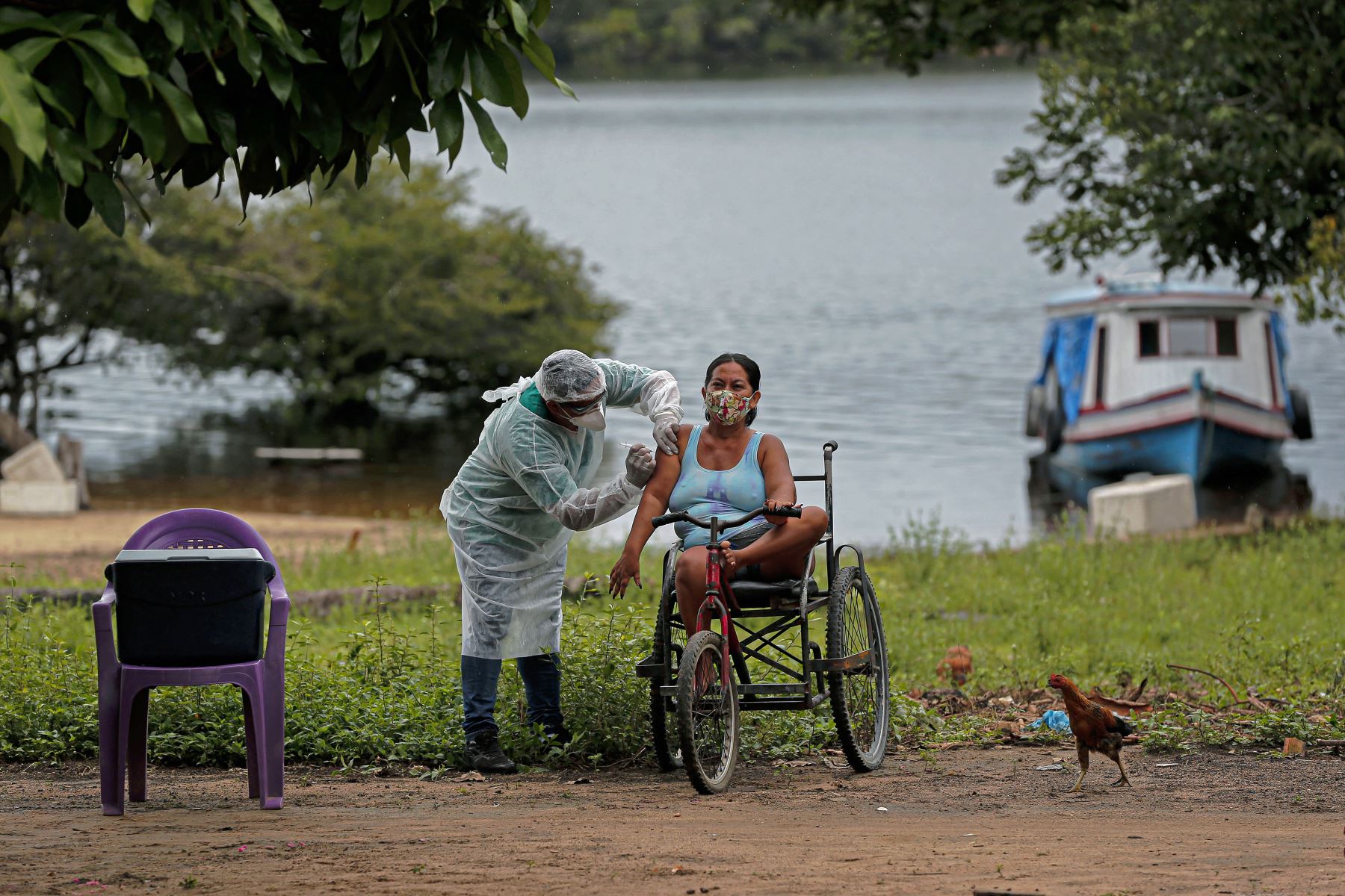 Un enfermero del Departamento de Salud Indígena administra una segunda dosis de la vacuna Covid-19 a una mujer en la aldea Esperanca do Rio Arapiun, en la región de la Baja Amazonia del estado de Pará, Brasil, el 14 de febrero de 2021. Foto: AFP