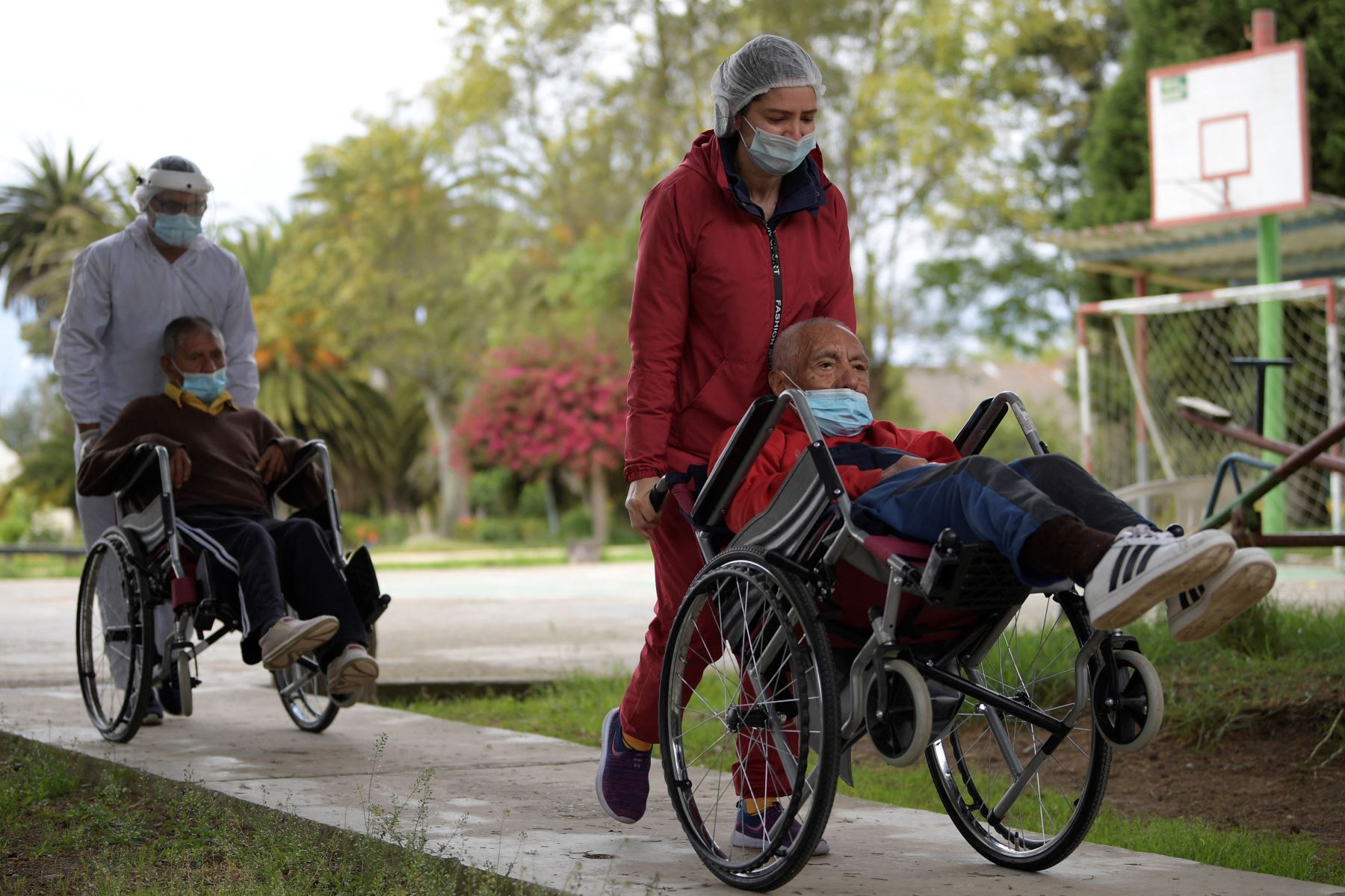 Ancianos colombianos son transportados en sillas de ruedas para recibir una dosis de la vacuna Sinovac contra COVID-19 en La Colonia, residencia de ancianos con discapacidad mental, en Sibate, Colombia. Foto: AFP