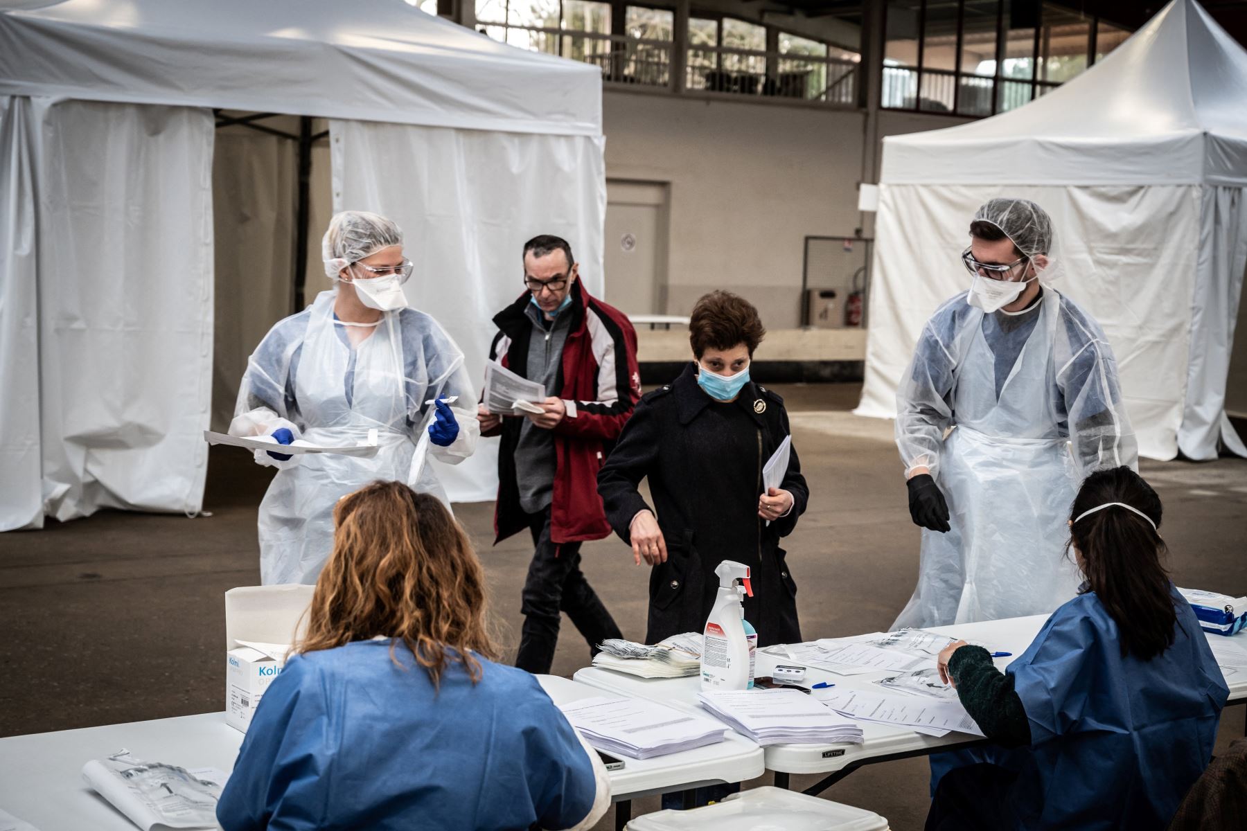 Los pacientes se registran para una prueba de saliva de Covid-19, en el Centro Boulodrome en Saint-Etienne, en el centro de Francia, el 22 de febrero de 2021, como parte de la segunda campaña de detección masiva de la ciudad para intentar detectar el nuevo coronavirus. Foto: AFP