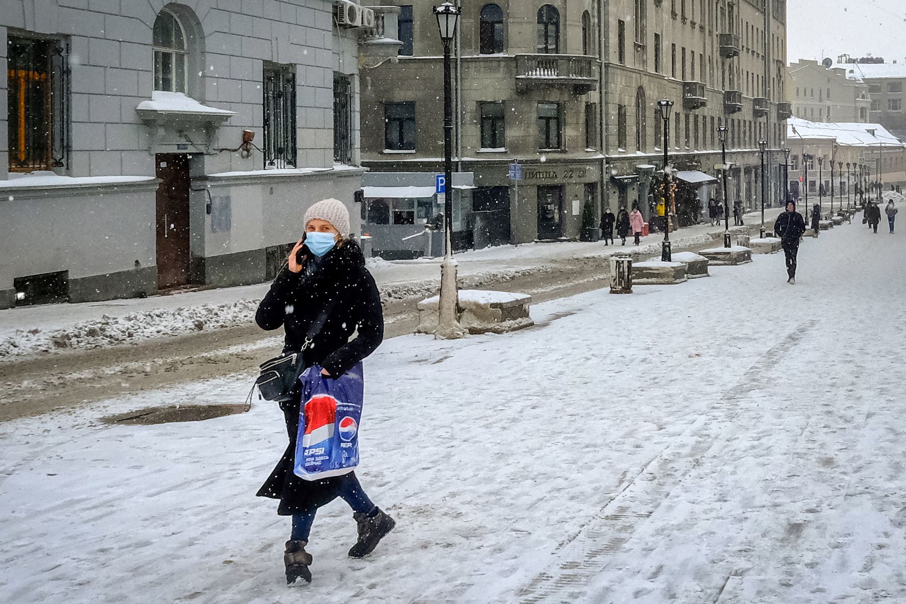 Una mujer con una mascarilla protectora camina en la nieve por una calle en el centro de Moscú en medio de la pandemia Covid-19- Foto: AFP