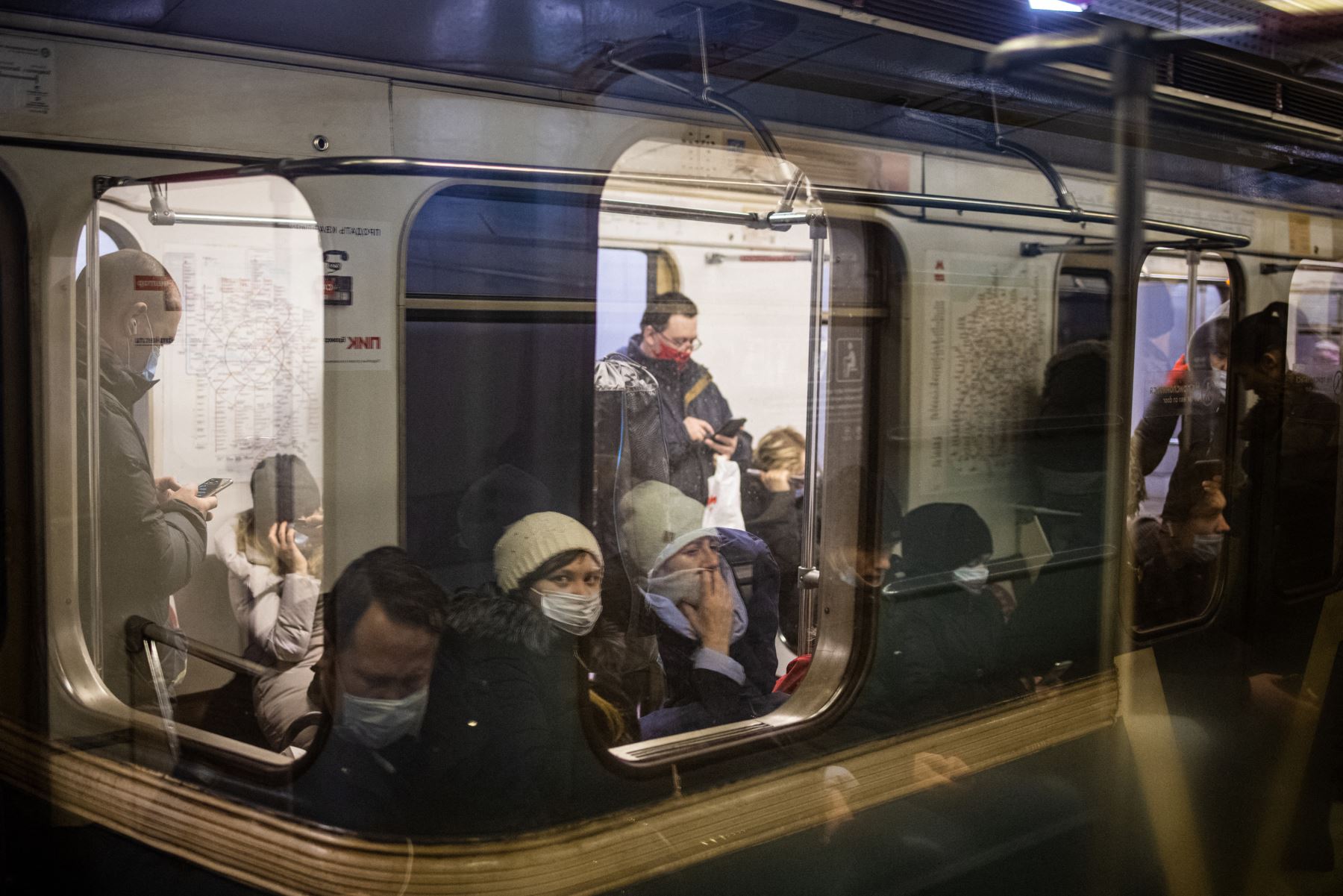 Los viajeros con máscaras protectoras contra el Covid-19 se sientan en un tren del metro en Moscú. Foto: AFP