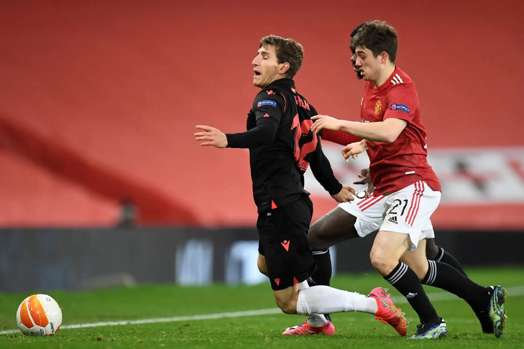 Aihen Munoz de la Real Sociedad en acción contra Daniel James del Manchester United durante los dieciseisavos de final de la UEFA Europa League. Foto: EFE