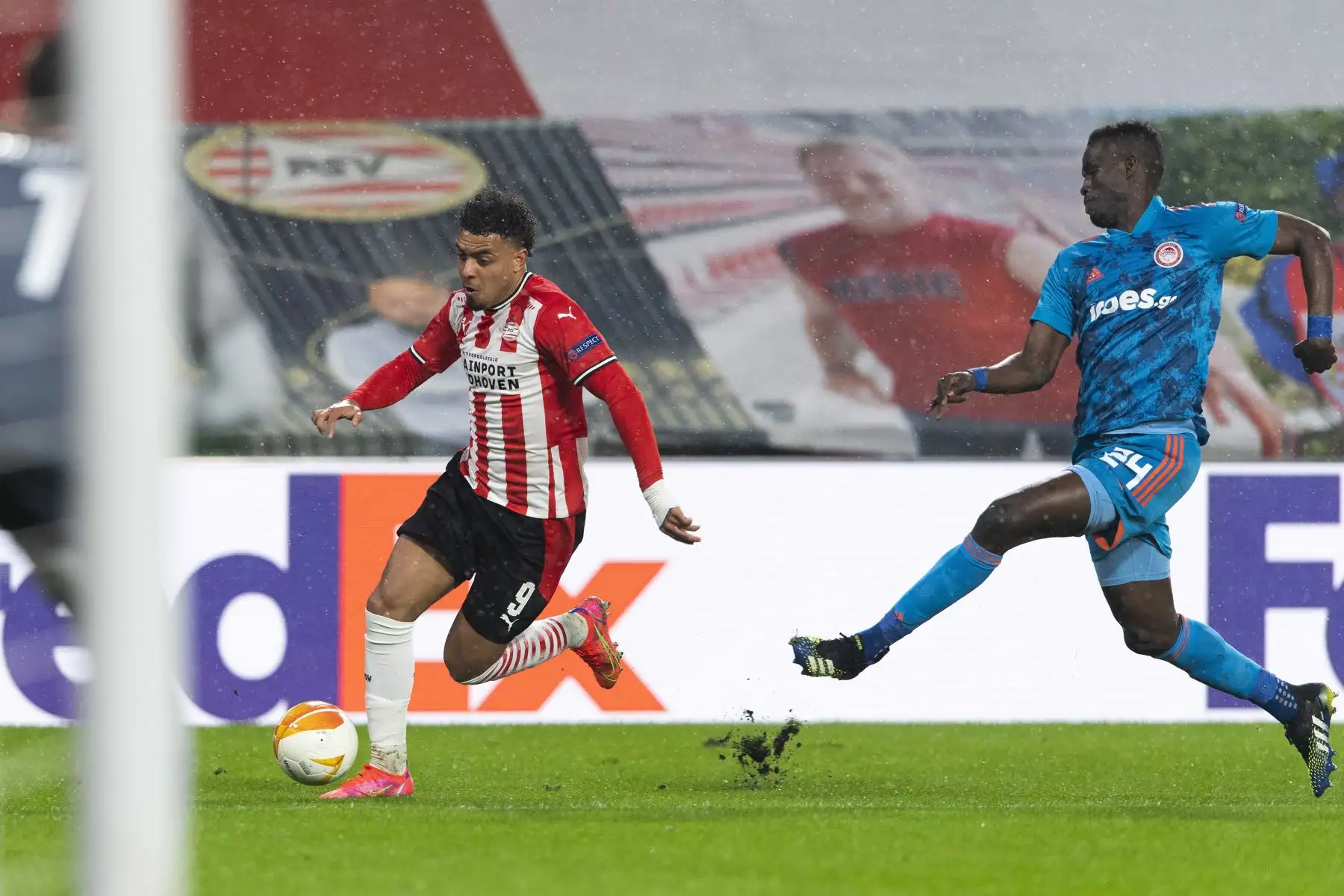 Donyell Malen de Eindhoven en acción contra Ousseynou Ba del Olympiacos durante los dieciseisavos de final de la UEFA Europa League. Foto: EFE