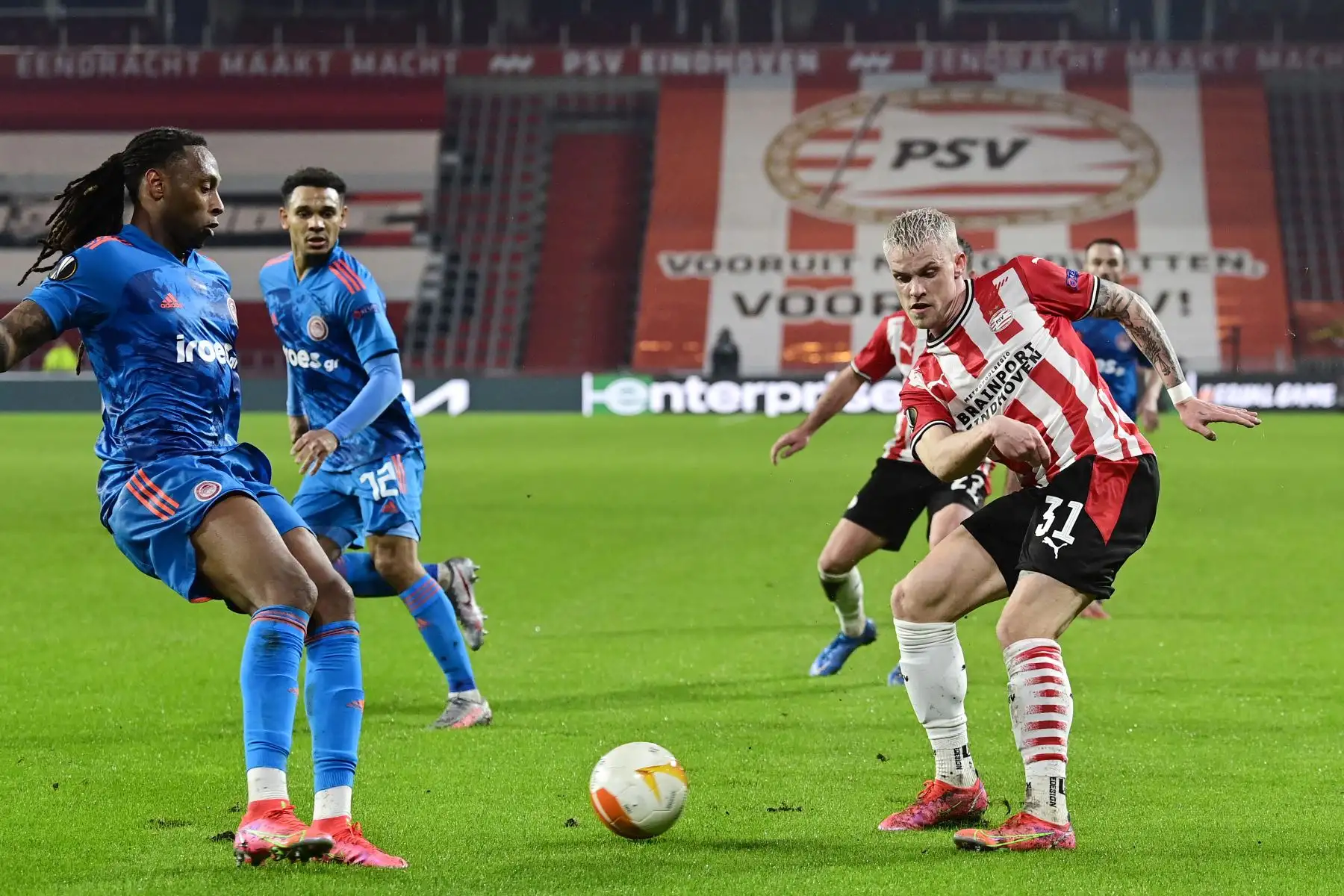 El defensor portugués del Olympiakos, Ruben Semedo, lucha por el balón con el defensor alemán del PSV Philipp Max durante los dieciseisavos de final de la UEFA Europa League. Foto: AFP