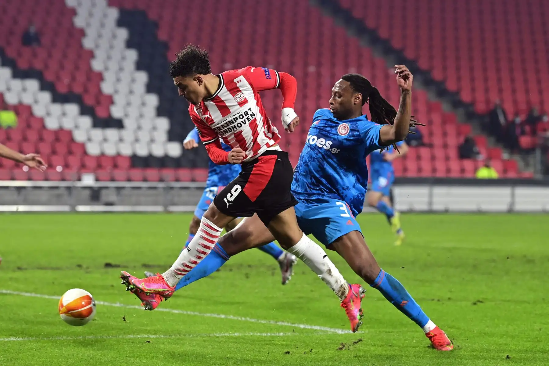El delantero holandés del PSV, Donyell Malen es desafiado por el defensor portugués del Olympiakos, Ruben Semedo, durante los dieciseisavos de final de la UEFA Europa League. Foto: AFP
