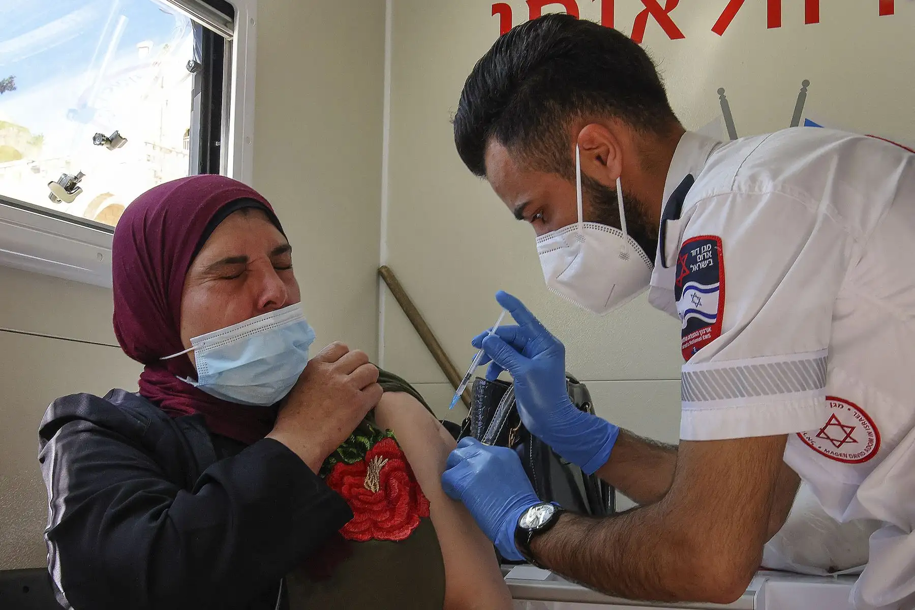 Un paramédico de los servicios médicos israelíes Magen David Adom vacuna a una mujer palestina en una clínica móvil el 26 de febrero de 2021 en la Puerta de Damasco en la Ciudad Vieja de Jerusalén. Foto: AFP