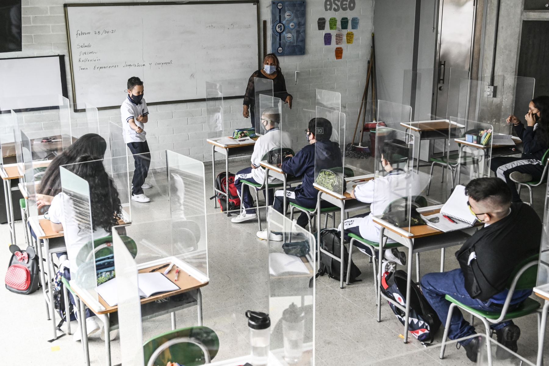 Los alumnos participan en una clase montada con pantallas protectoras en el Colegio Público Antonio José Sucre, en medio de la pandemia del Covid-19 en Colombia. Foto: AFP