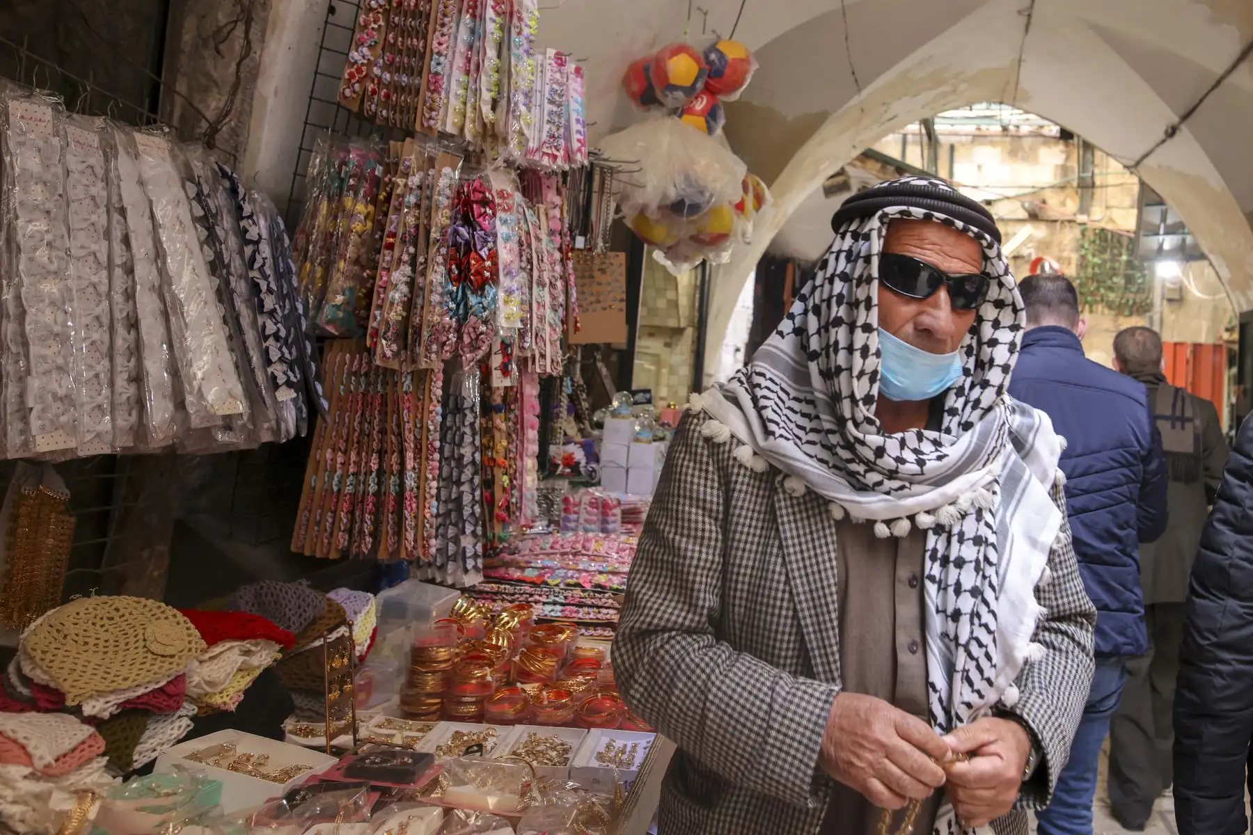 Un palestino vestido con una máscara pasa frente a las tiendas de la Ciudad Vieja de Jerusalén, en medio de la pandemia de coronavirus, el 24 de febrero de 2021. Foto: AFP