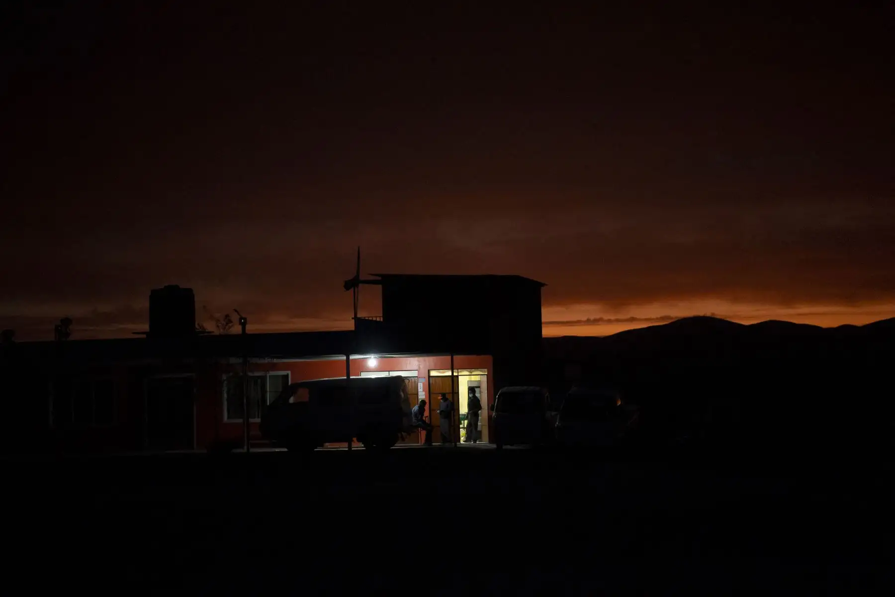 Los migrantes venezolanos descansan frente a un restaurante, luego de cruzar desde Bolivia hacia Huara en Chile. Foto: AFP