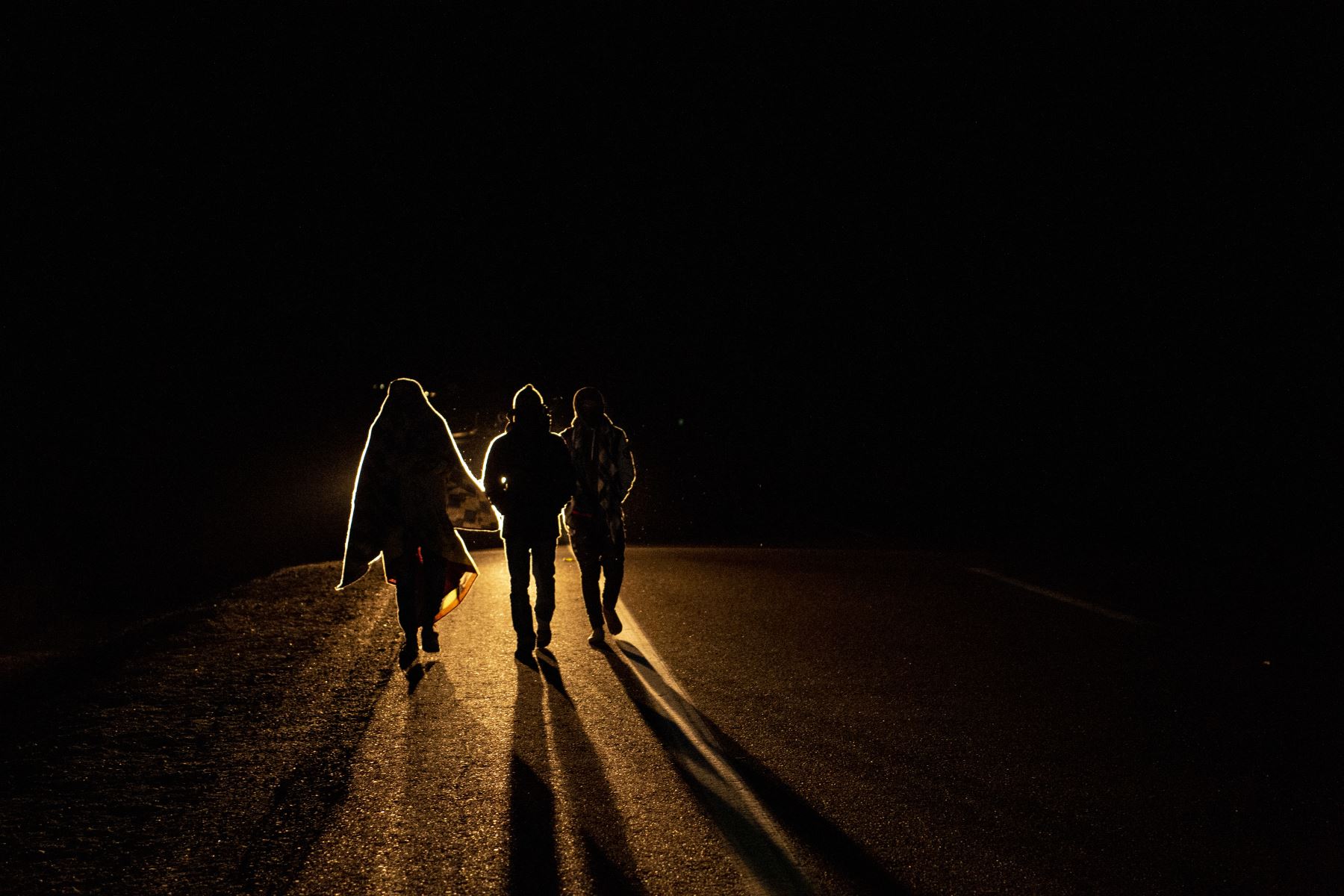 El migrante venezolano Rubi Alexander G. y amigos caminan bajo temperaturas frías en la noche por la carretera que une Colchane con Iquique, luego de cruzar desde Bolivia. Foto: AFP