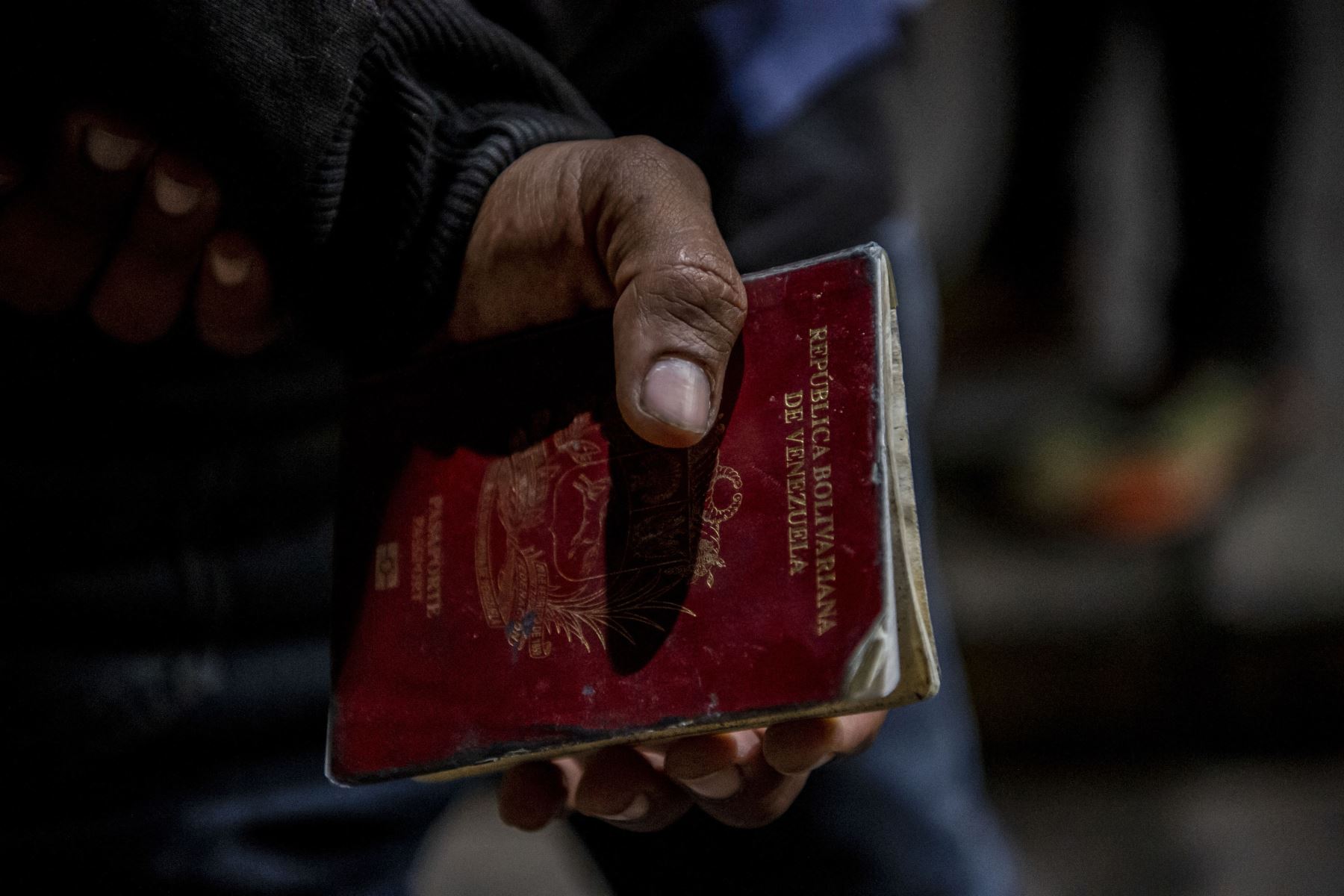 El migrante venezolano Reinaldo, de 26 años, sostiene su pasaporte, necesario para tramitar su pase sanitario antes de abordar un autobús a Santiago de Chile en medio de la pandemia de COVID-19. Foto: AFP