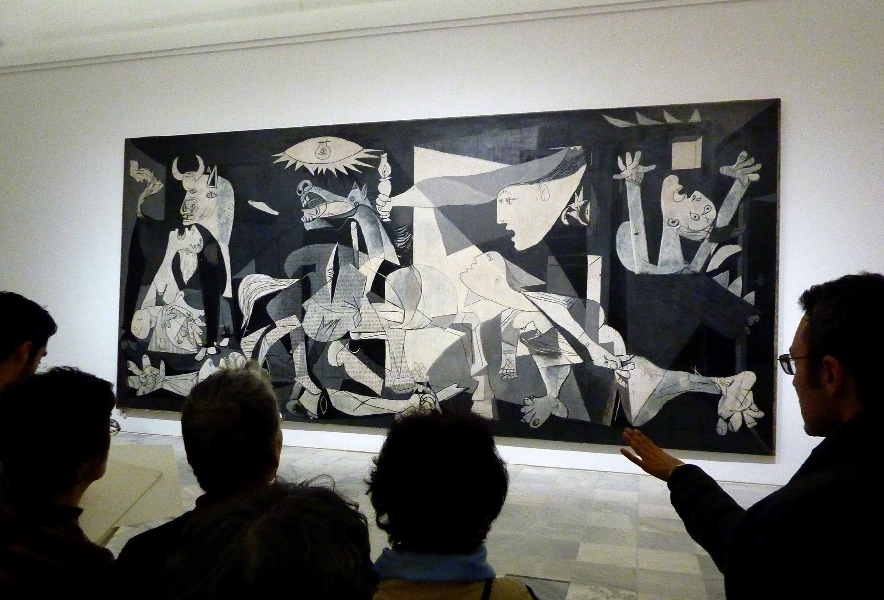 La gente mira el cuadro original de la Guernica de Pablo Picasso en el museo Reina Sofía de Madrid. Foto: AFP
