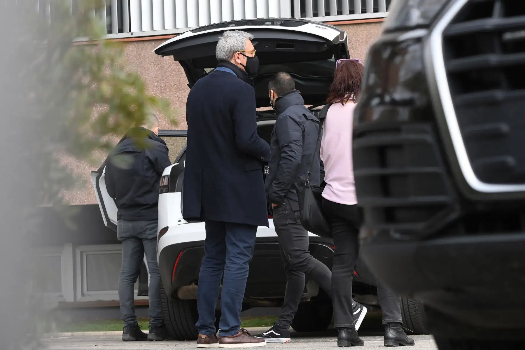 El abogado español Jorge Navarro observa a la policía regional catalana revisar el automóvil de Roman Gómez Ponti, jefe de servicios legales del FC Barcelona, ​​frente a las oficinas del Fútbol Club Barcelona, el 1 de marzo de 2021. Foto: AFP