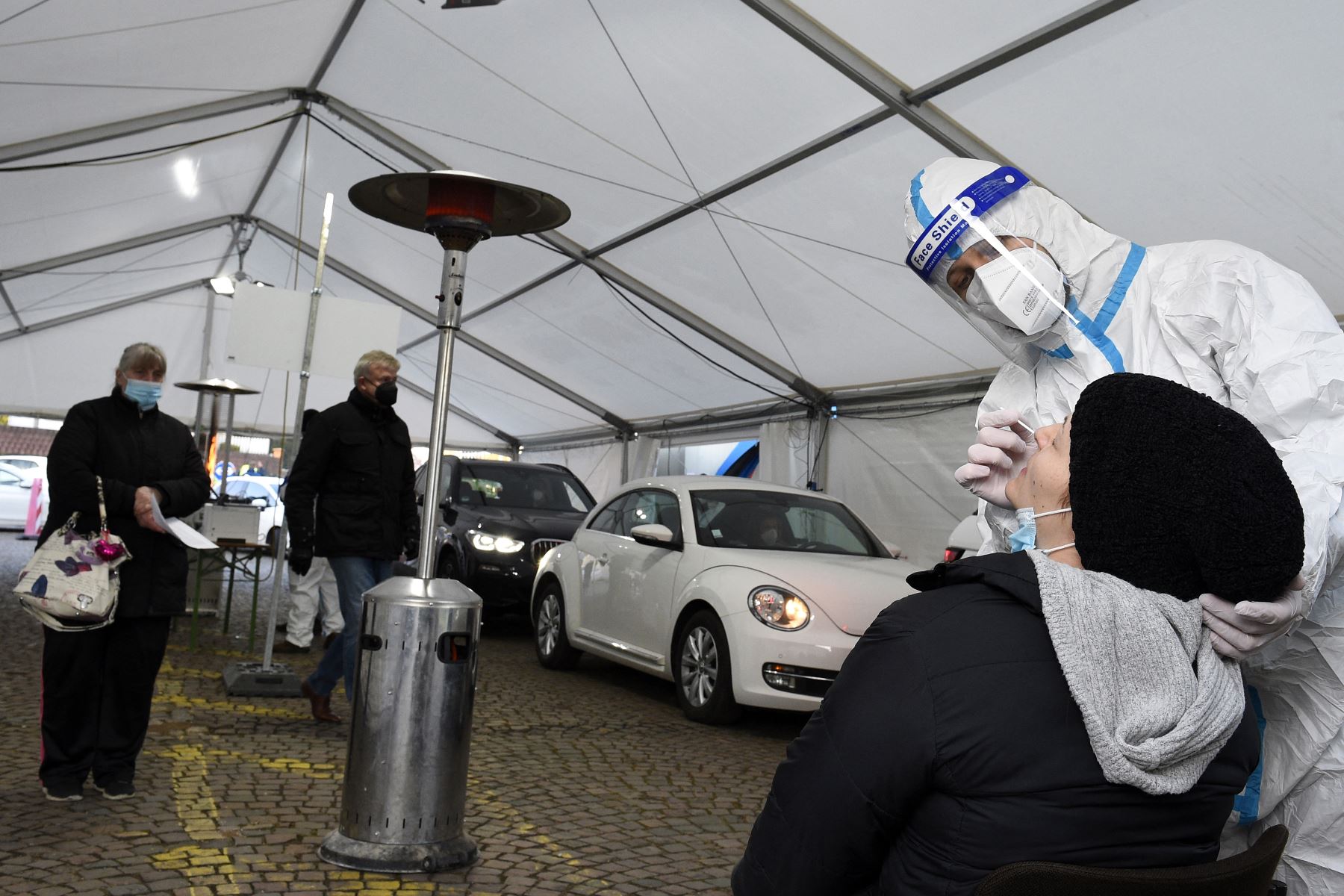 Un trabajador de la salud toma una muestra de hisopo nasal de un viajero para una prueba rápida antigénica Covid-19 en un centro de pruebas, en Saarbrucken, Alemania. Foto: AFP
