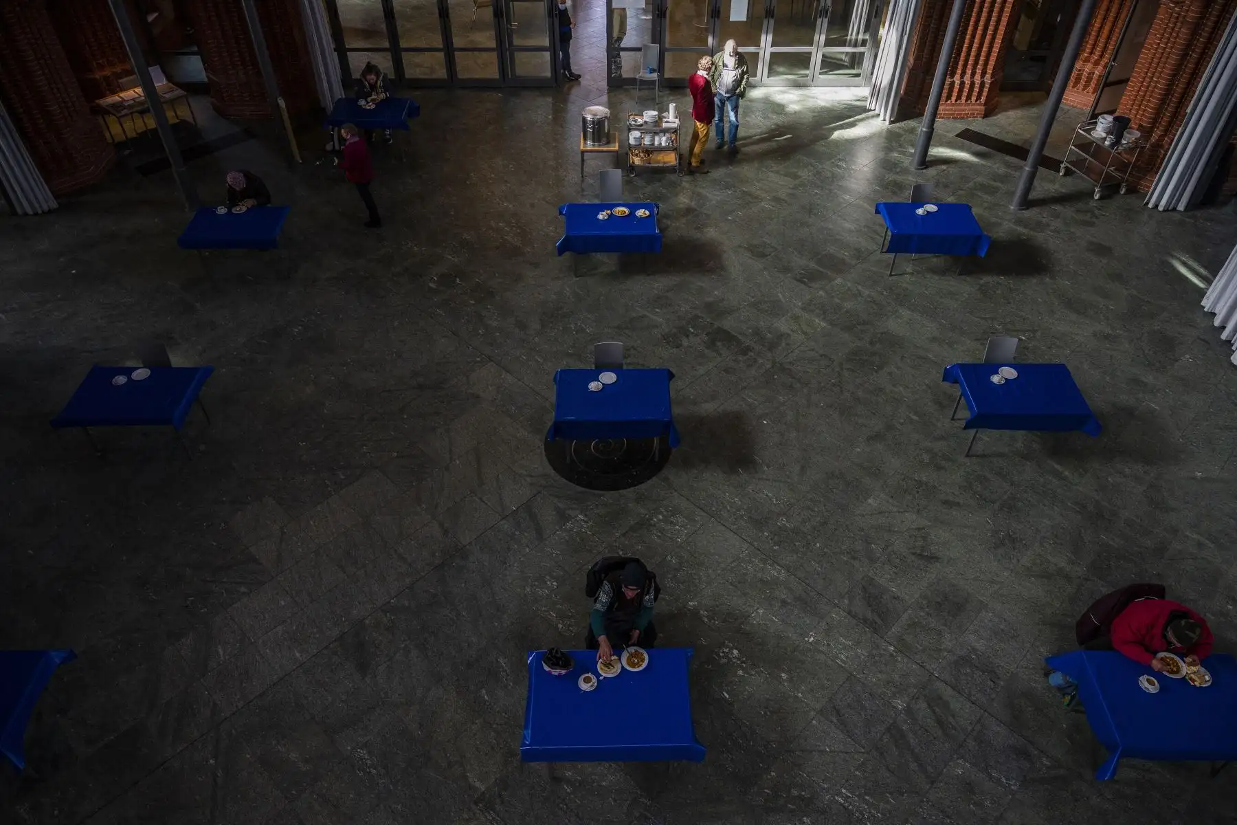 Un grupo de personas almuerza en un comedor de beneficencia para los necesitados y las personas sin hogar, en la iglesia de la Santa Cruz, en el distrito de Kreuzberg de Berlín. Foto: AFP