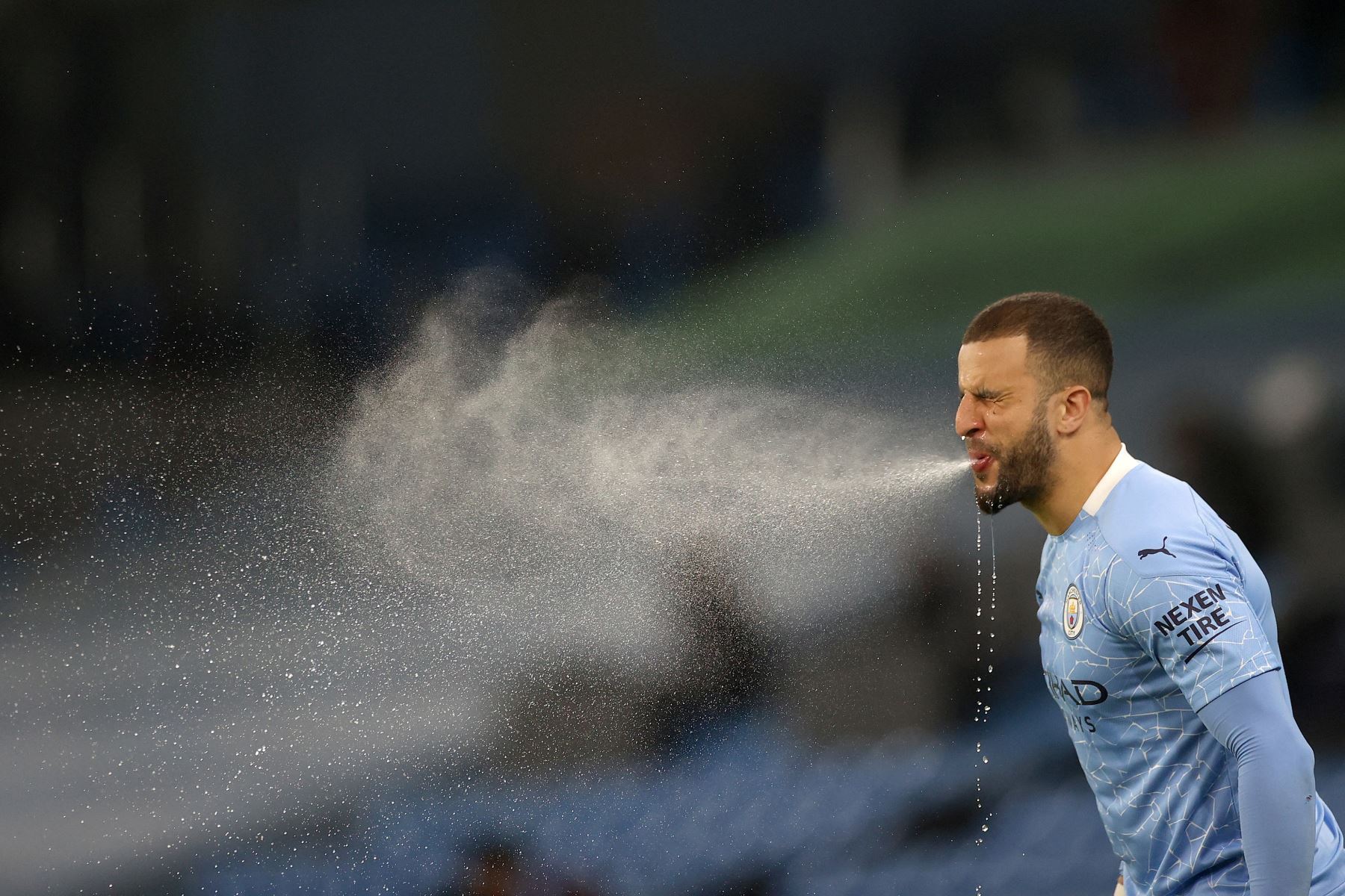 El defensor inglés del Manchester City, Kyle Walker, r escupe el agua tras hidratarse en el partido ante Wolverhamptom Wanderers en el Etihad Stadium, en Manchester. Foto: AFP