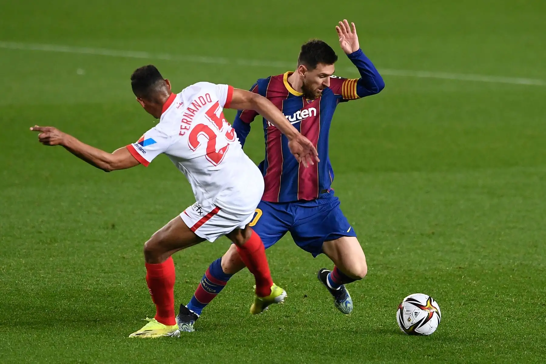 El centrocampista brasileño del Sevilla Fernando Reges compite con el delantero argentino del Barcelona Lionel Messi durante la semifinal de la Copa del Rey de España. Foto: AFP