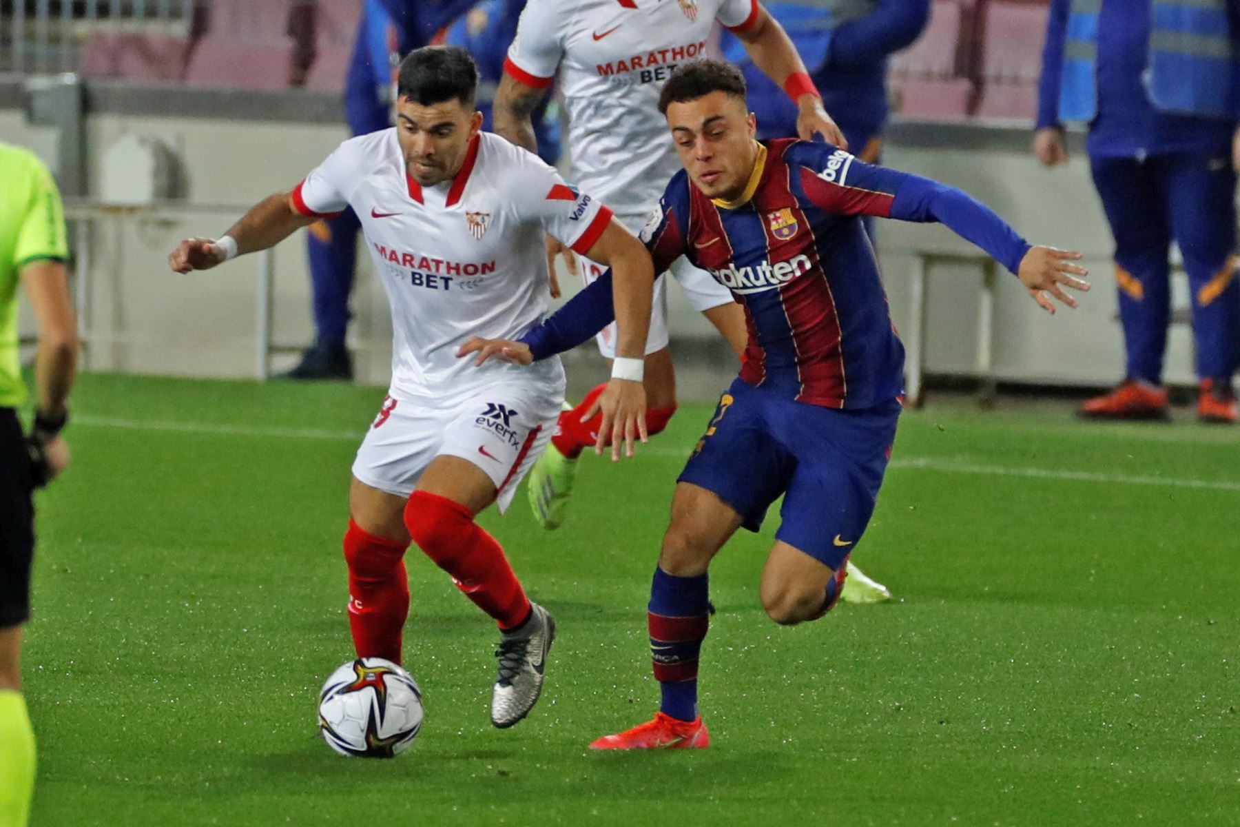 El jugador del FC Barcelona, ​​Dest y su rival, Acuña, del Sevilla CF, se enfrentan por el balón durante el partido de vuelta de semifinales de la Copa del Rey, en el Camp Nou. Foto: EFE