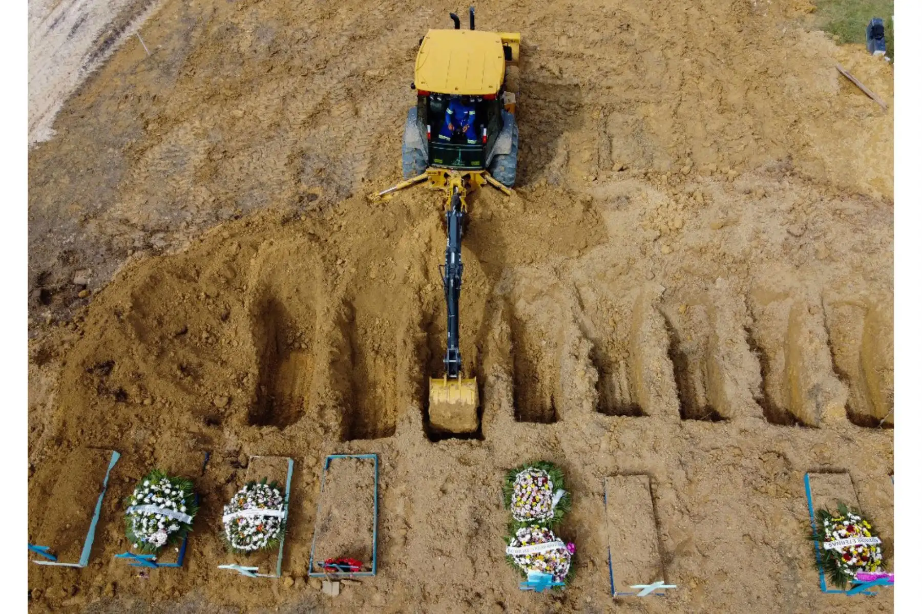 Esta foto de archivo tomada el 8 de enero de 2021 muestra una vista aérea de un tractor cavando tumbas en una nueva área del cementerio Nossa Senhora Aparecida reservada para las víctimas del covid-19, en Manaus, Brasil. Foto: AFP