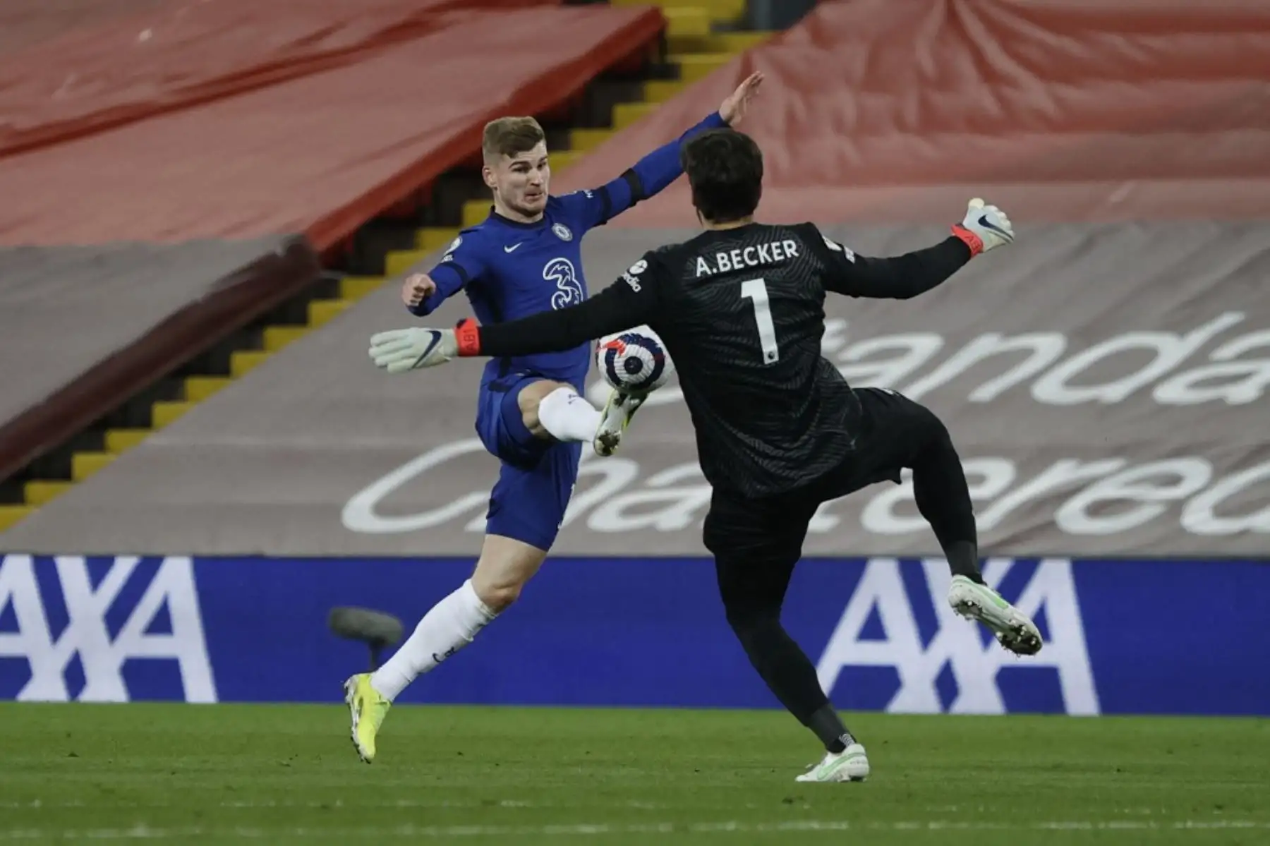 El delantero alemán del Chelsea Timo Werner golpea al portero brasileño del Liverpool Alisson Becker al balón y pone el balón en la red, pero el VAR descarta el gol por fuera de juego durante el partido de fútbol de la Premier League inglesa entre Liverpool y Chelsea en Anfield en Liverpool. Foto: AFP