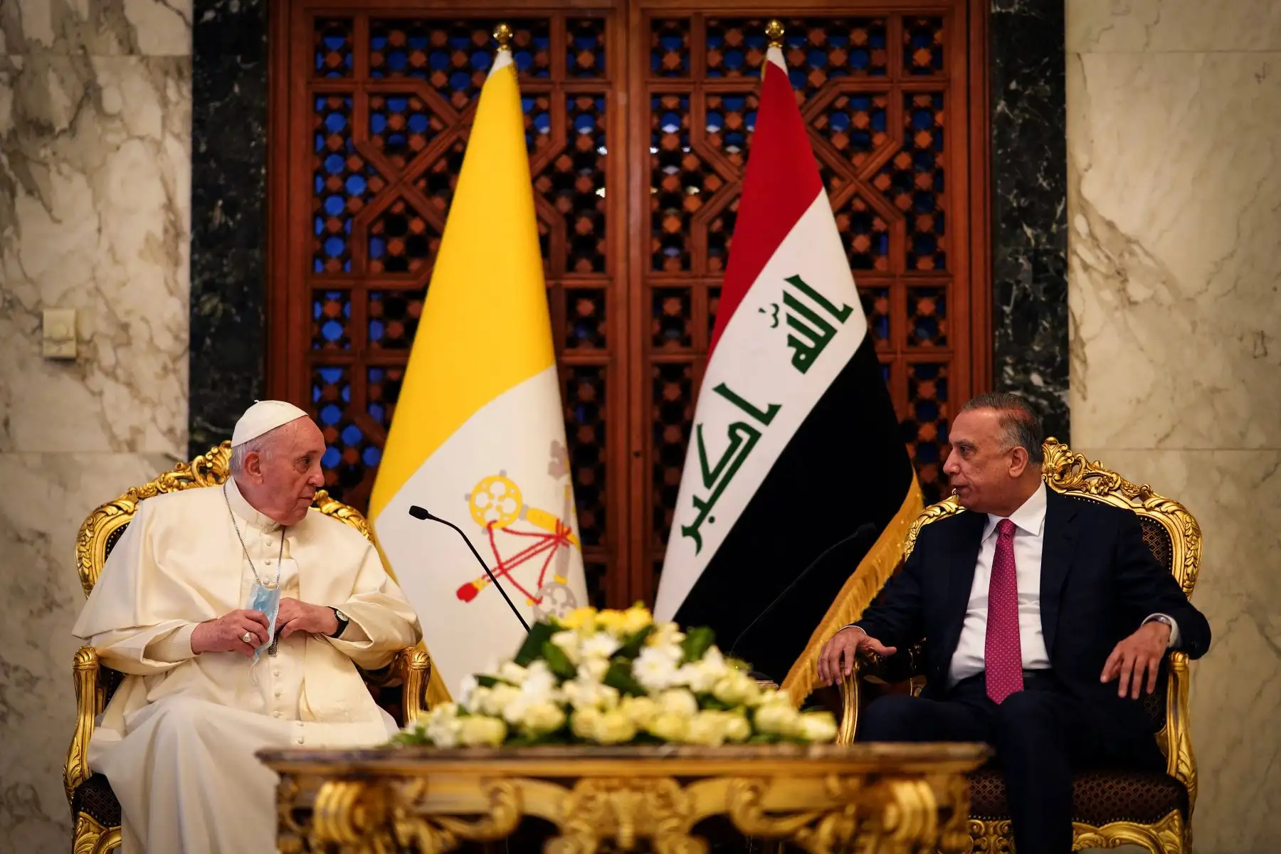 El primer ministro de Irak, Mustafa al-Kadhemi (derecha), da la bienvenida al Papa Francisco en la sala VIP del aeropuerto de Bagdad. Foto: AFP