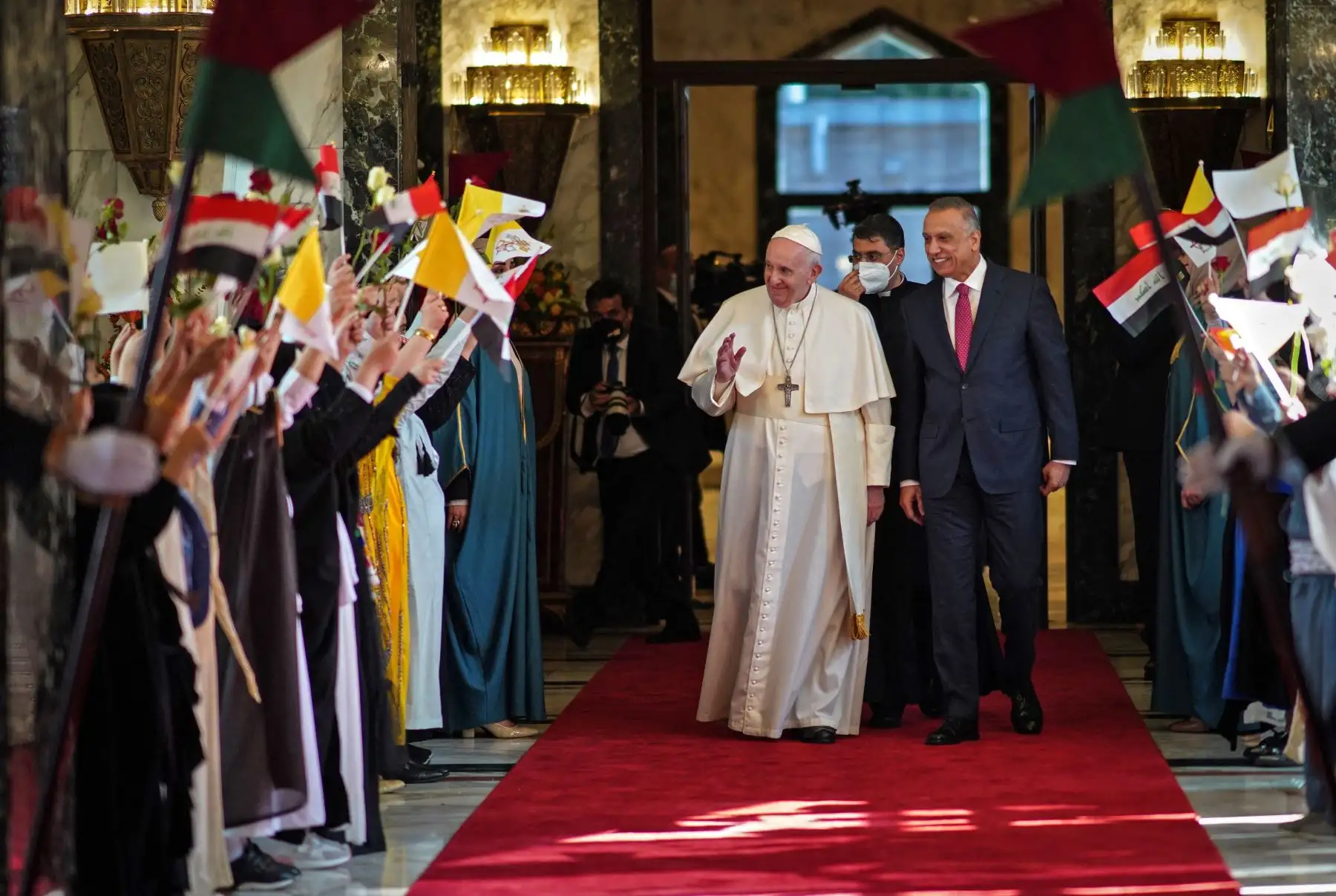 El primer ministro de Irak, Mustafa al-Kadhemi (derecha), da la bienvenida al Papa Francisco en la sala VIP del aeropuerto de Bagdad. Foto: AFP
