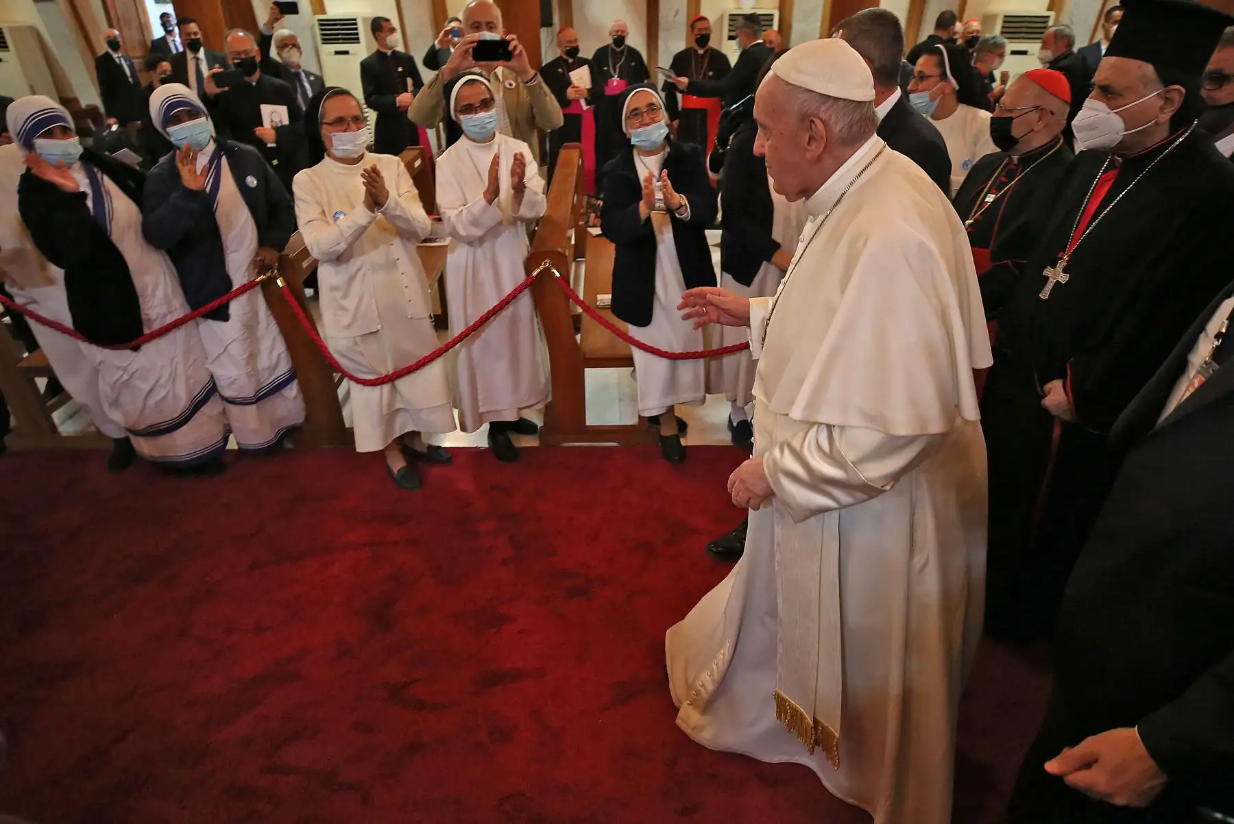 El Papa Francisco saluda a monjas y clérigos a su llegada a la Catedral siriocatólica de Nuestra Señora de la Salvación (Sayidat al-Najat) en la capital Bagdad al comienzo de la primera visita papal a Irak. En su discurso a los fieles en Bagdad, el Papa Francisco expresó su gratitud a sus compañeros del clero por apoyar a los cristianos de Irak, cuya población ha disminuido debido al conflicto. Foto: AFP