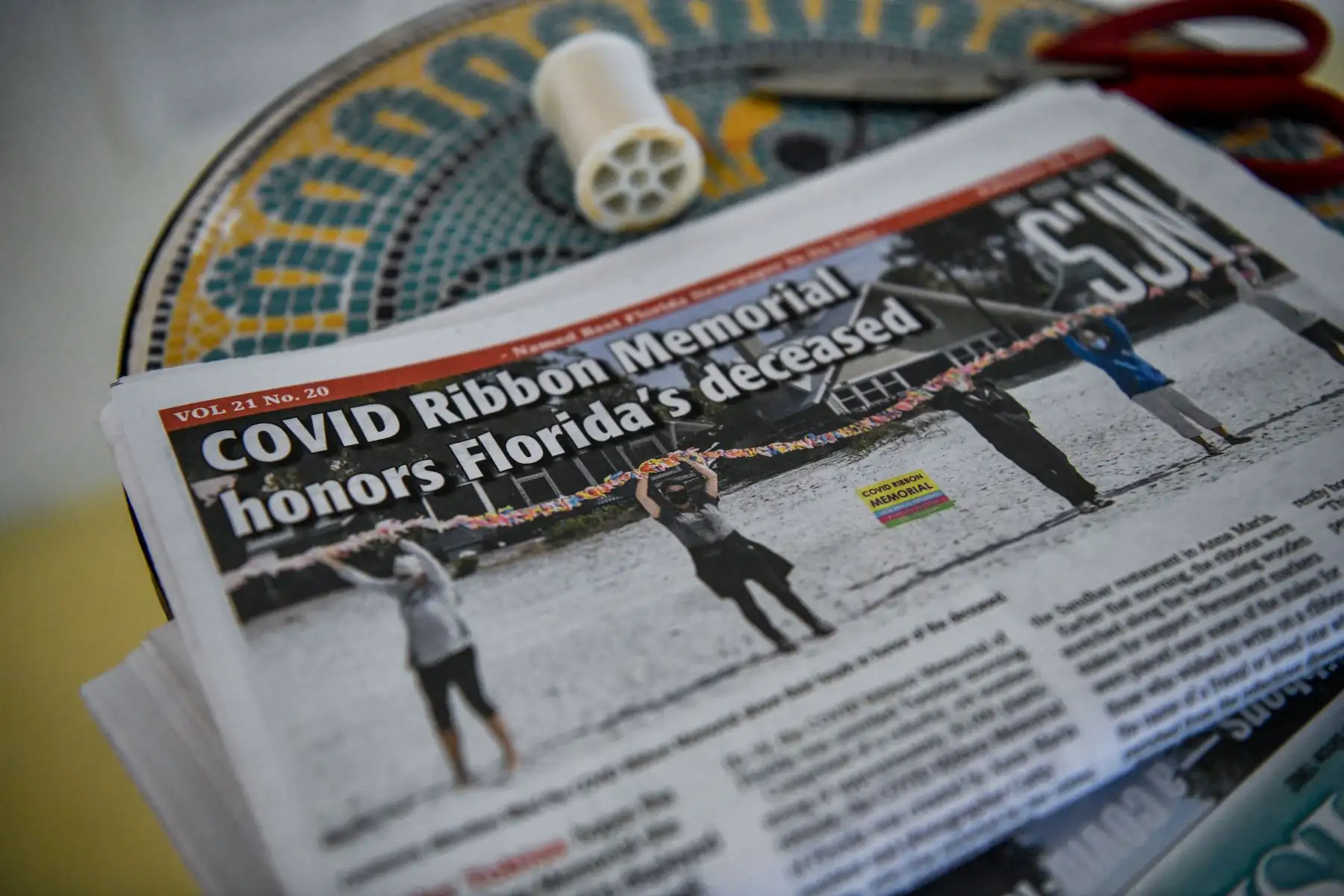 Un periódico informa sobre la cinta conmemorativa de Cathy Tobias para las víctimas de Covid-19, en Anna Maria Island. Ahora hay más de 30.000 cintas, en todos los colores. Foto: AFP