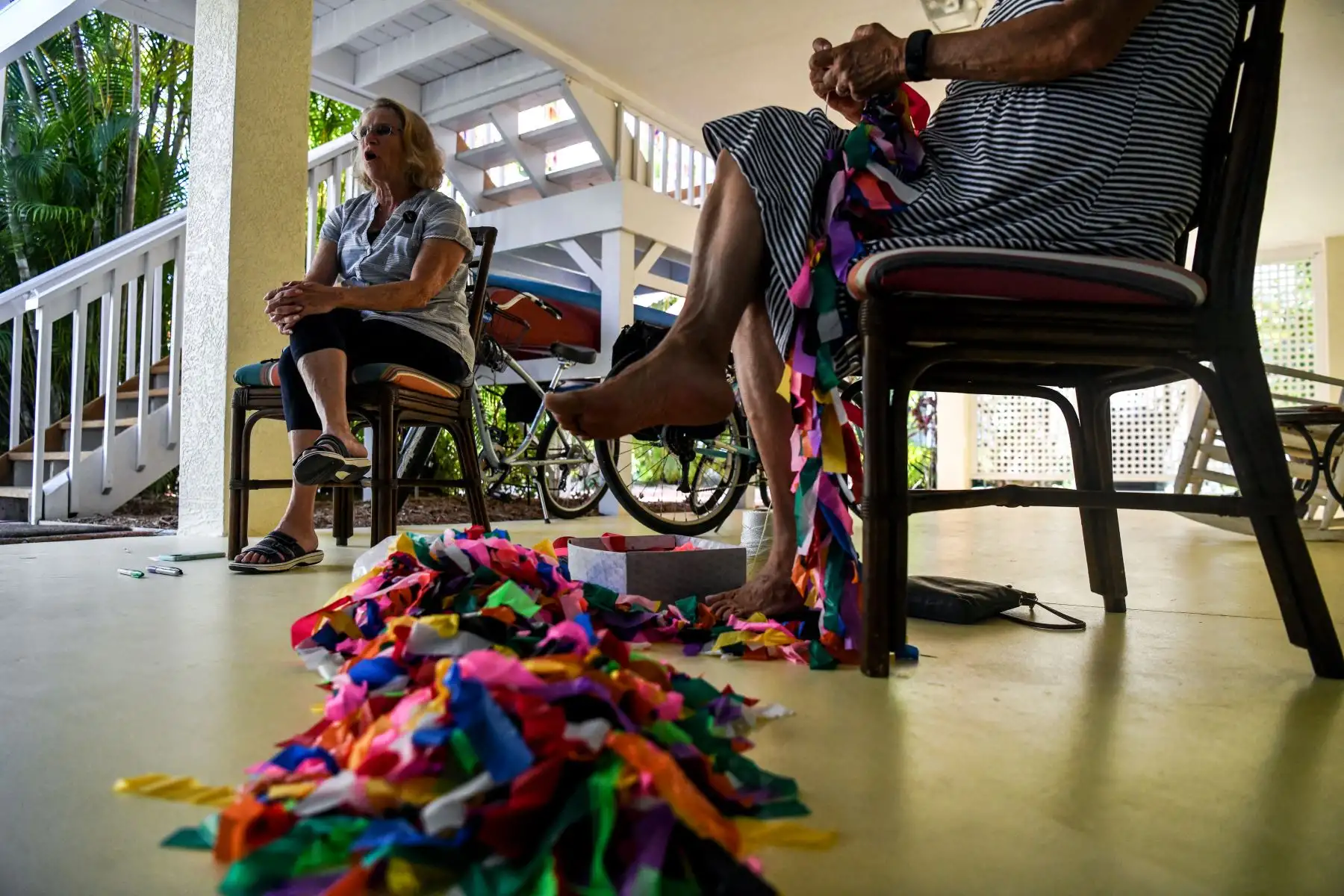 Cuando Cathy Tobias comenzó a atar una cinta a un cuerda por cada muerte de Covid-19 en Florida, no tenía idea de que todo su patio terminaría cubierto de colores. El llamativo tributo a quienes murieron en el Estado del Sol durante la pandemia atraviesa su patio. Foto: AFP