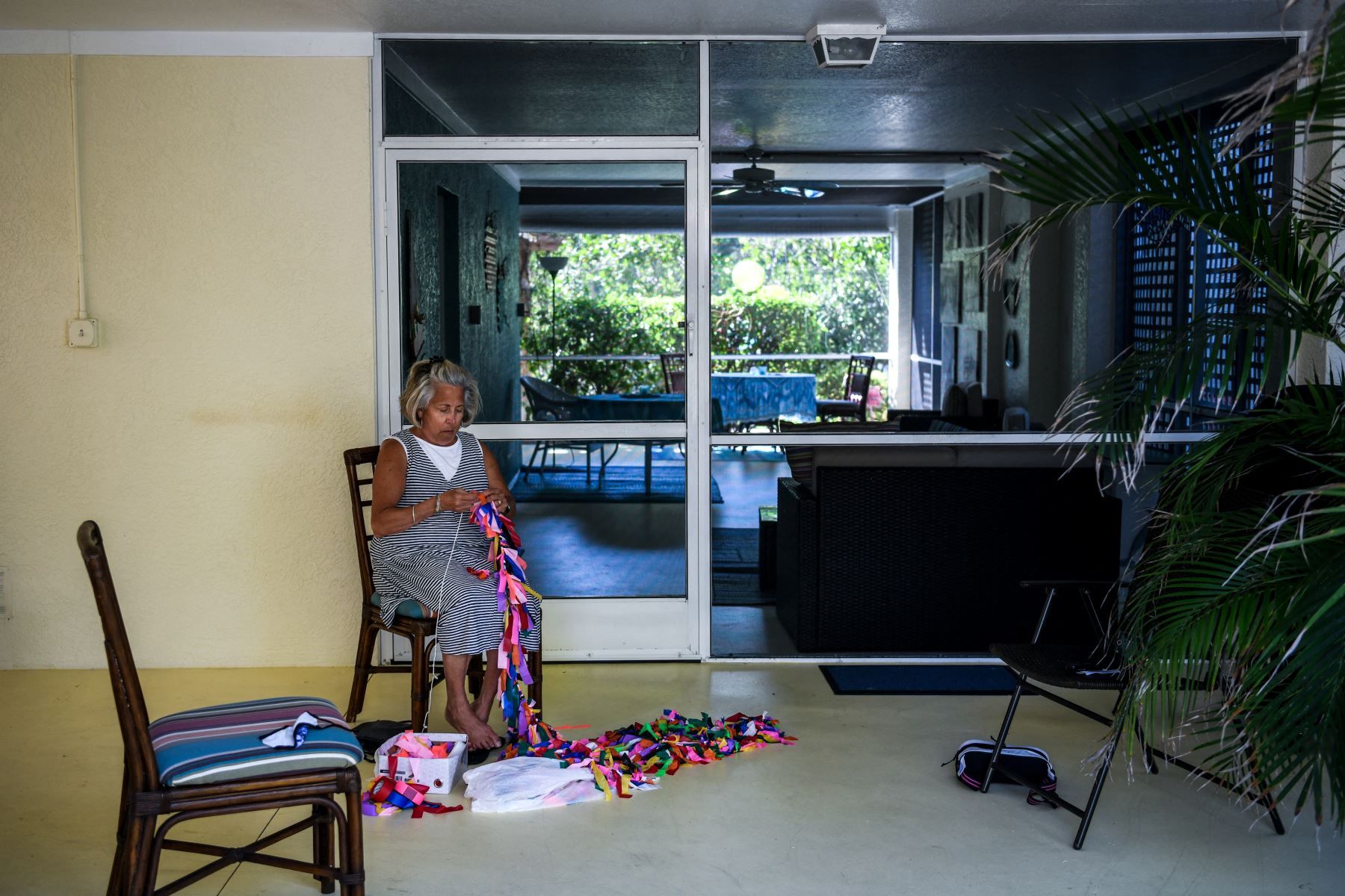 La amiga de Cathy Tobias, Lucy Kancy, de 69 años, ata cintas en una cuerda que representa a las víctimas de Covid-19. Foto: AFP