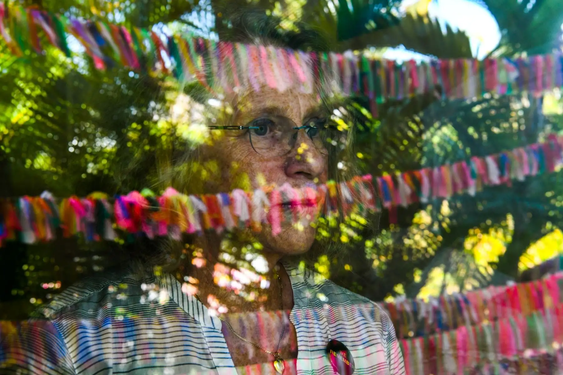 Cathy Tobias, de 67 años, posa mientras mira su patio, que se ha convertido en un monumento a las víctimas del Covid-19, en Anna Maria Island, Florida. Foto: AFP