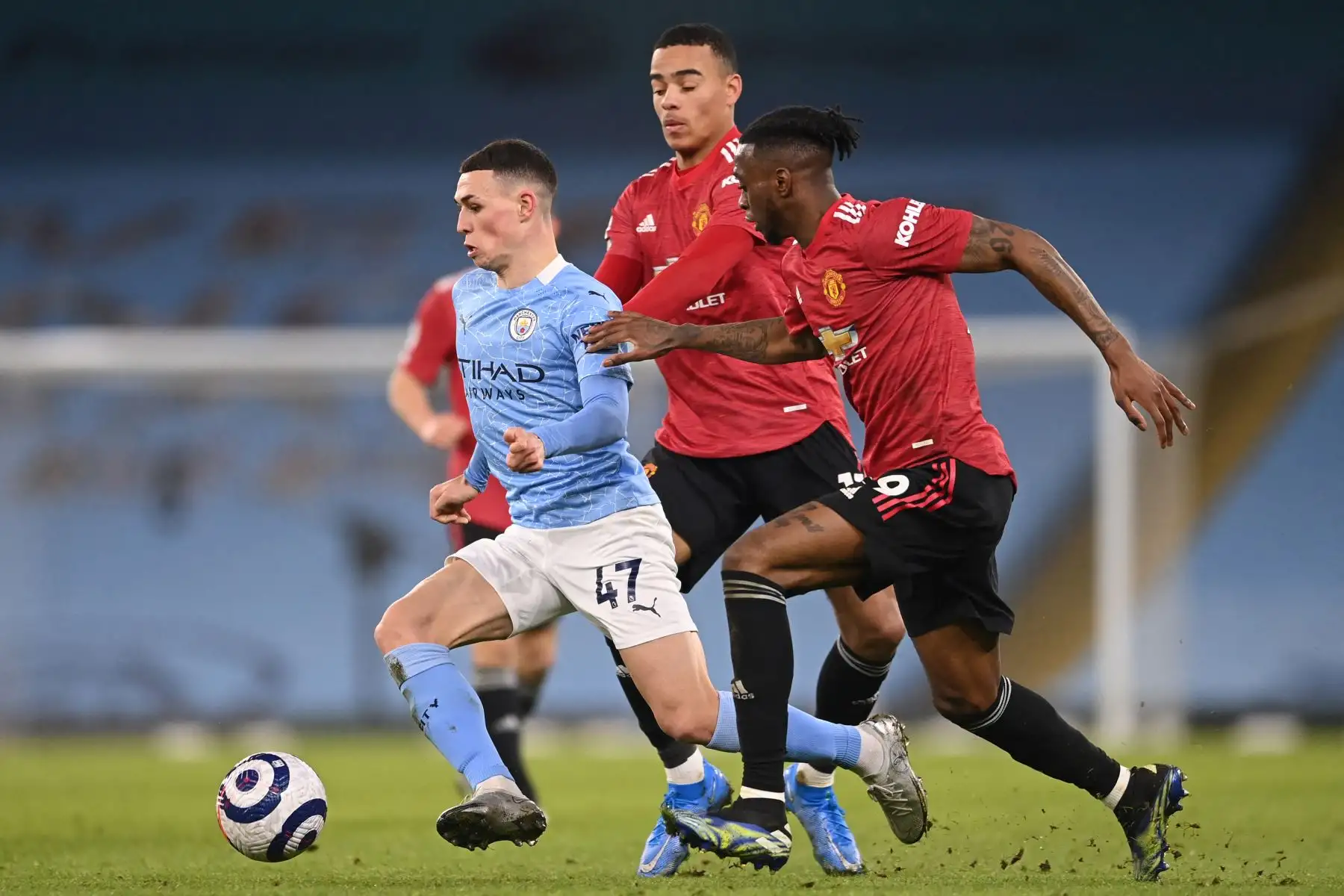 El centrocampista inglés del Manchester City Phil Foden  huye del delantero inglés del Manchester United Mason Greenwood  y el defensor inglés del Manchester United Aaron Wan-Bissaka  durante el partido de fútbol de la Premier League inglesa entre el Manchester City y el Manchester United.
Foto : AFP
