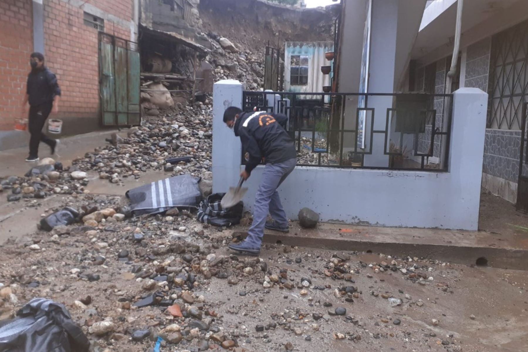 Un ciudadano remueve lodo y escombros desplazados por las lluvias en la región Áncash.