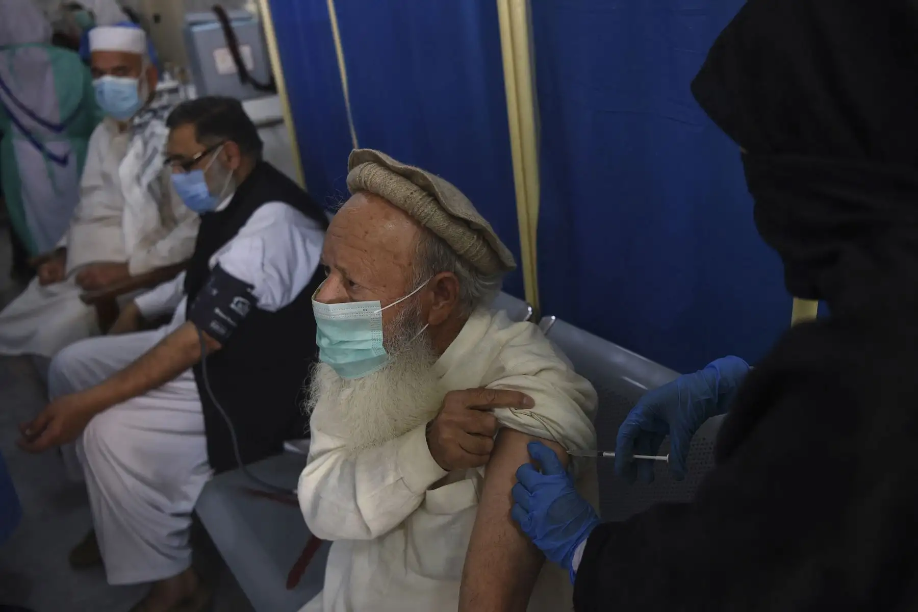 Un anciano recibe una dosis de la vacuna Sinopharm de fabricación china contra el coronavirus Covid-19, en un centro de vacunación en Peshawar, en Pakistan. Foto: AFP