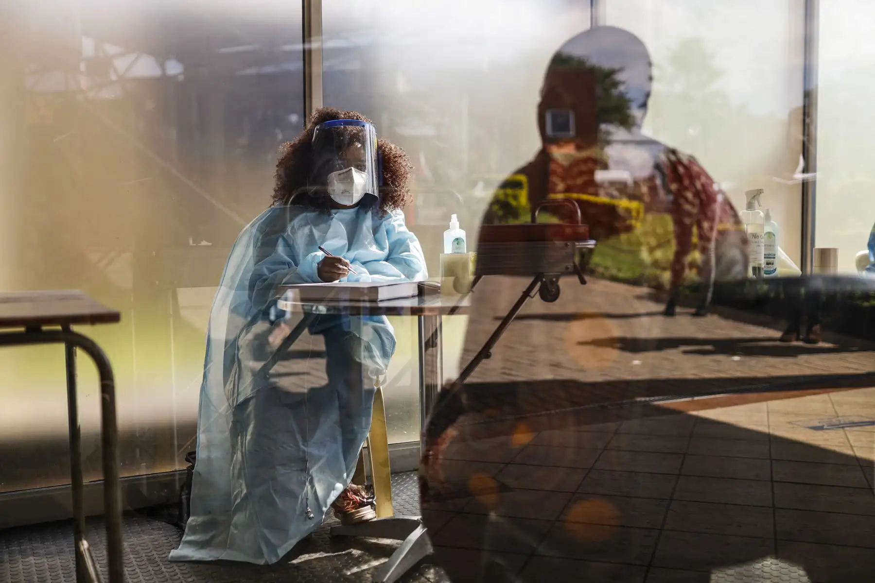 Un trabajador de salud examina a los visitantes para detectar síntomas de COVID-19 en el Hospital Tembisa en South Africa, el 1 de marzo de 2021. Foto: AFP