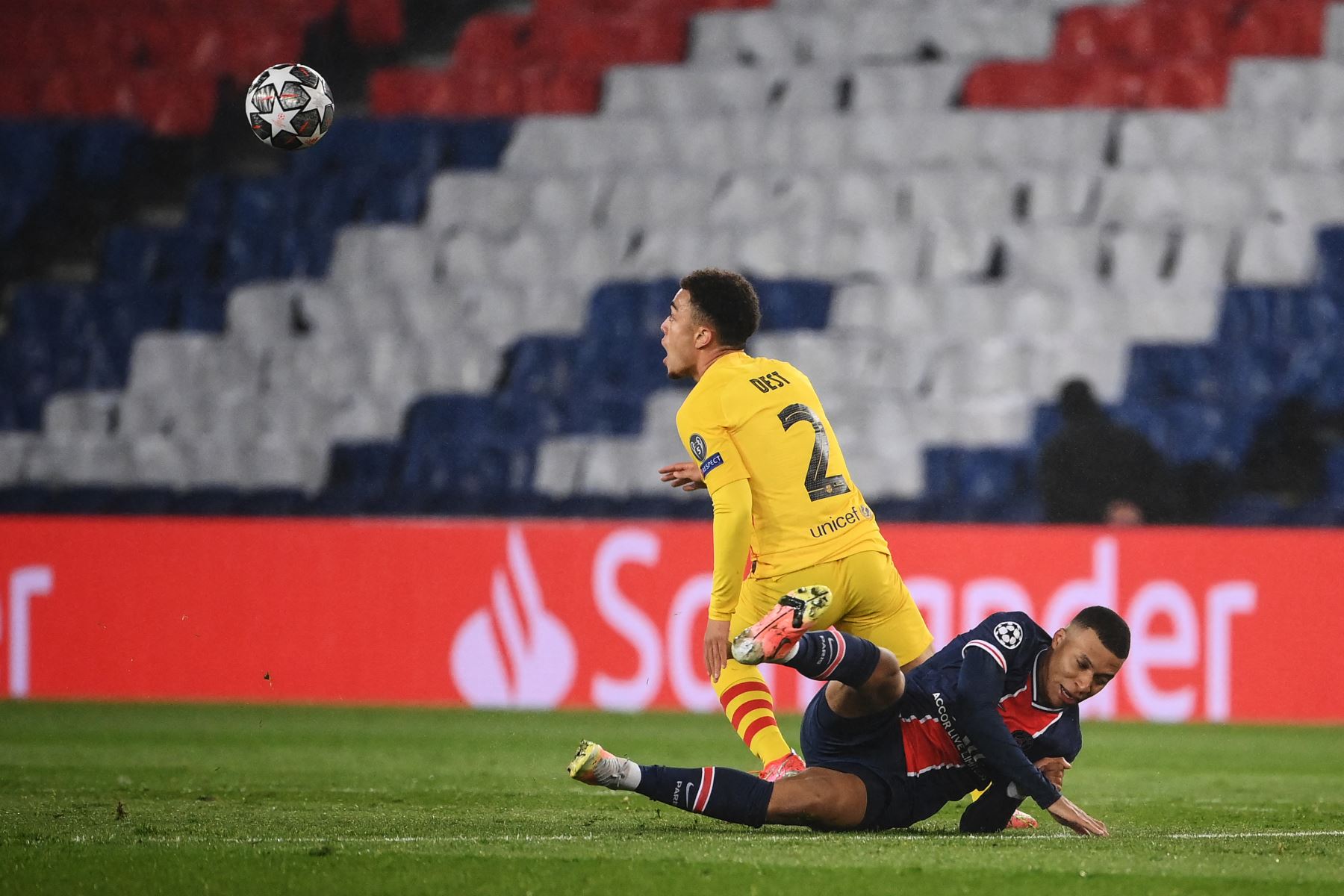 El defensor estadounidense del Barcelona Sergino Dest lucha por el balón con el delantero francés del Paris Saint-Germain Kylian Mbappé durante la ronda de la Liga de Campeones de la UEFA. Foto: AFP